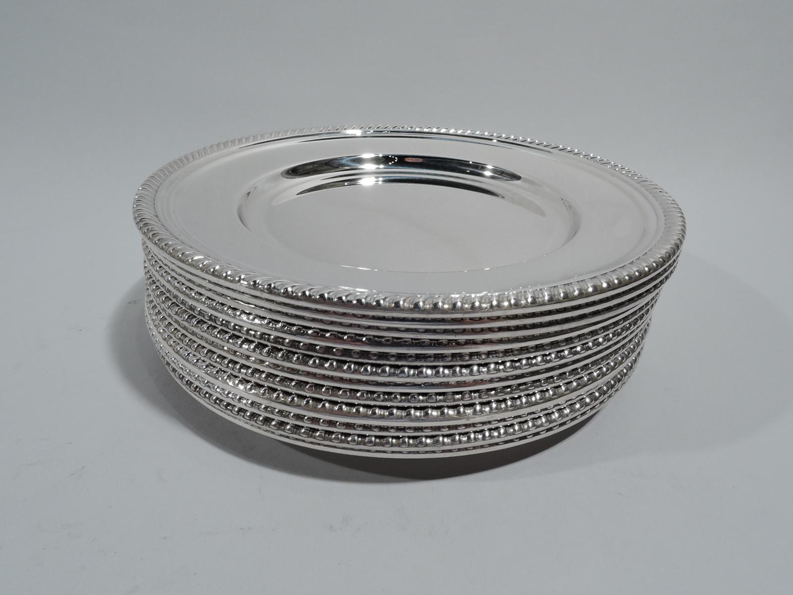 Set of 12 Kensington sterling silver bread and butter plates. Made by Gorham in Providence. Each: Round with deep well and Georgian-style gadrooned rim. Fully marked including maker’s stamp and no. 180. Total weight: 36.5 troy ounces.
