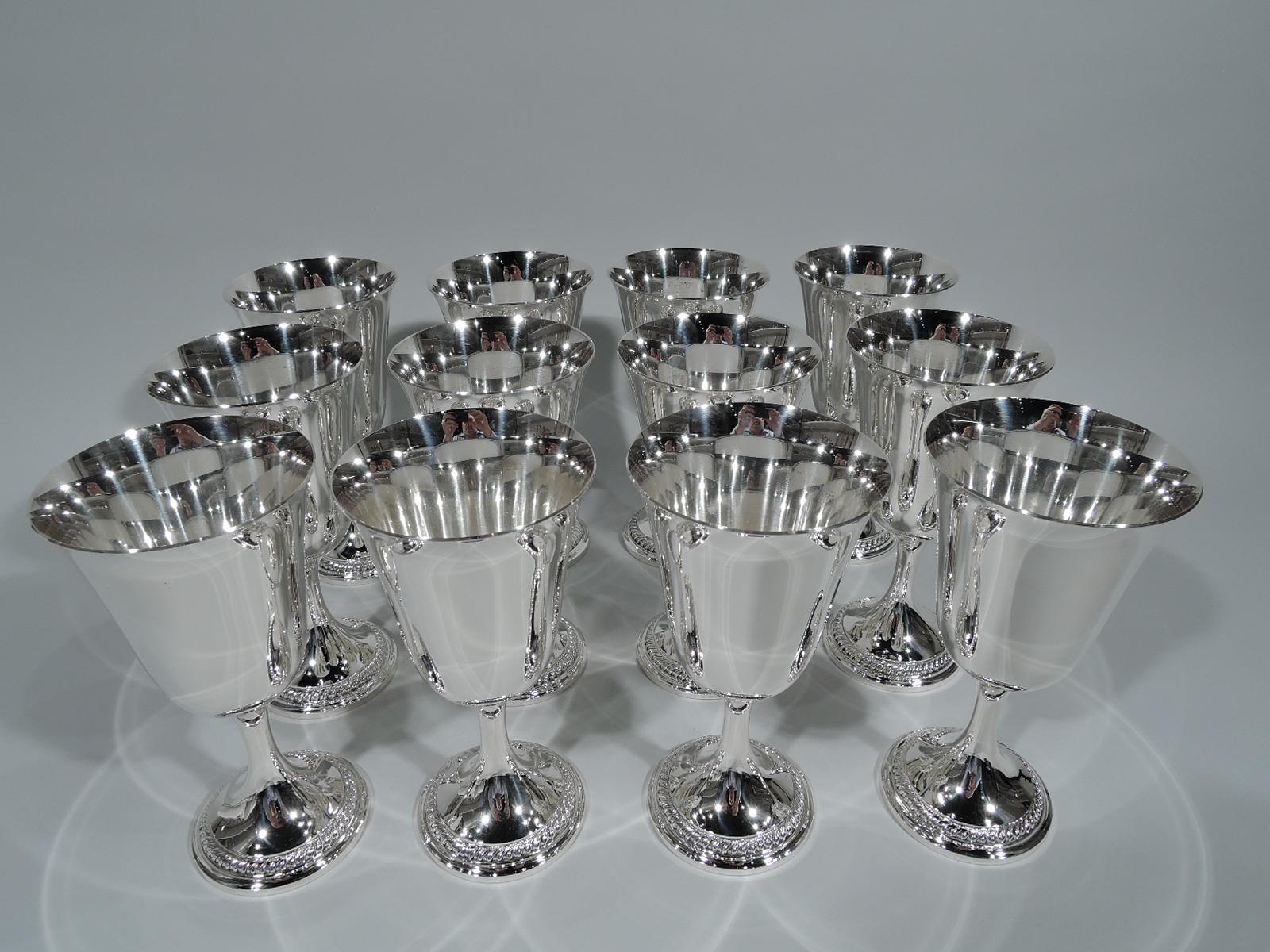 Set of 12 sterling silver goblets. Made by Gorham in Providence. Each: Tapering bowl with flared rim, cylindrical stem, and raised foot with gadrooned rim. Sleek Modern form with a Georgian touch. Hallmark includes no. 533. Total weight: 70 troy