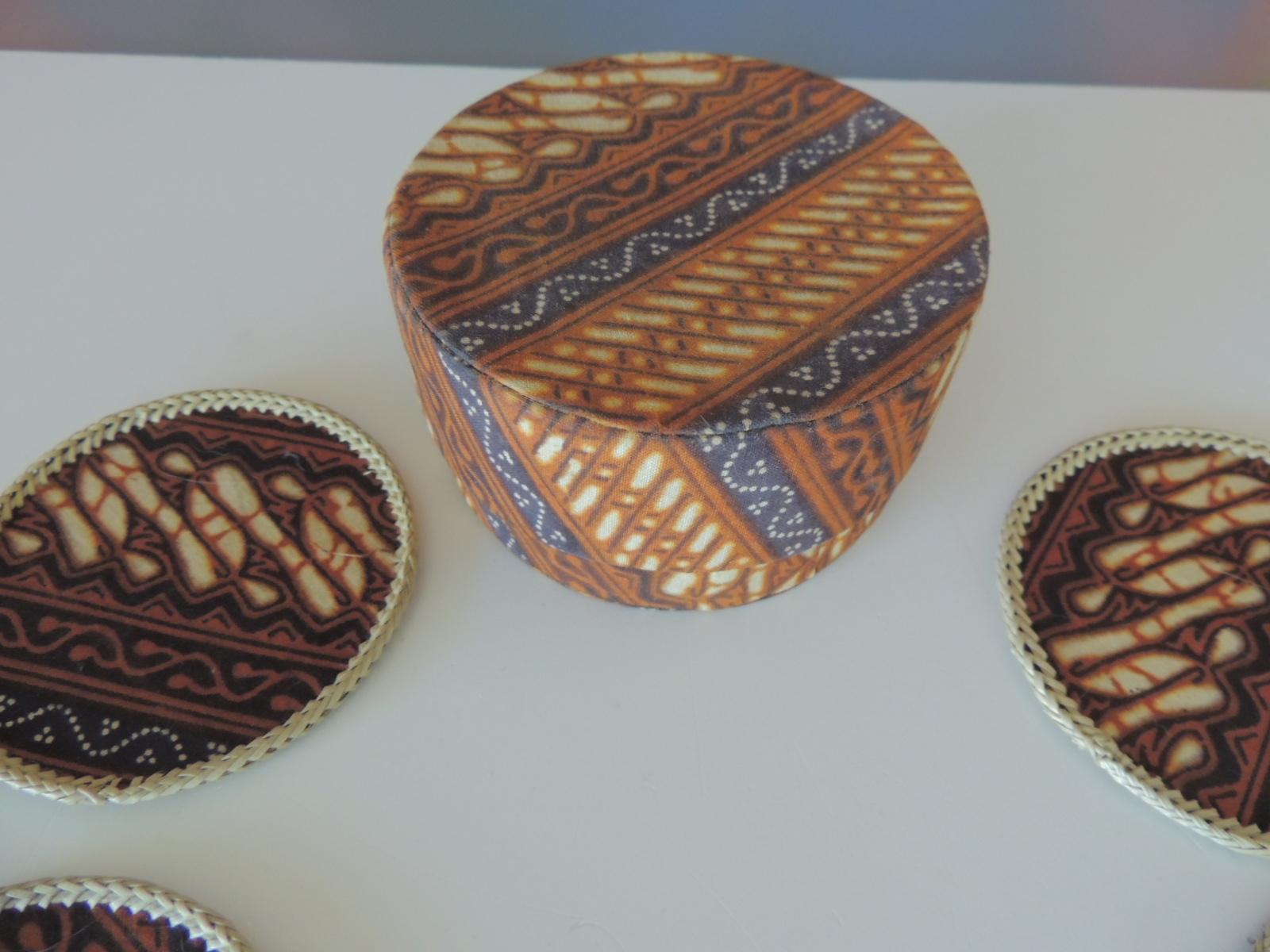 Set of '12' hand woven round batik fabric coasters
with original storage box.
Yellow and brown textile
Printed.