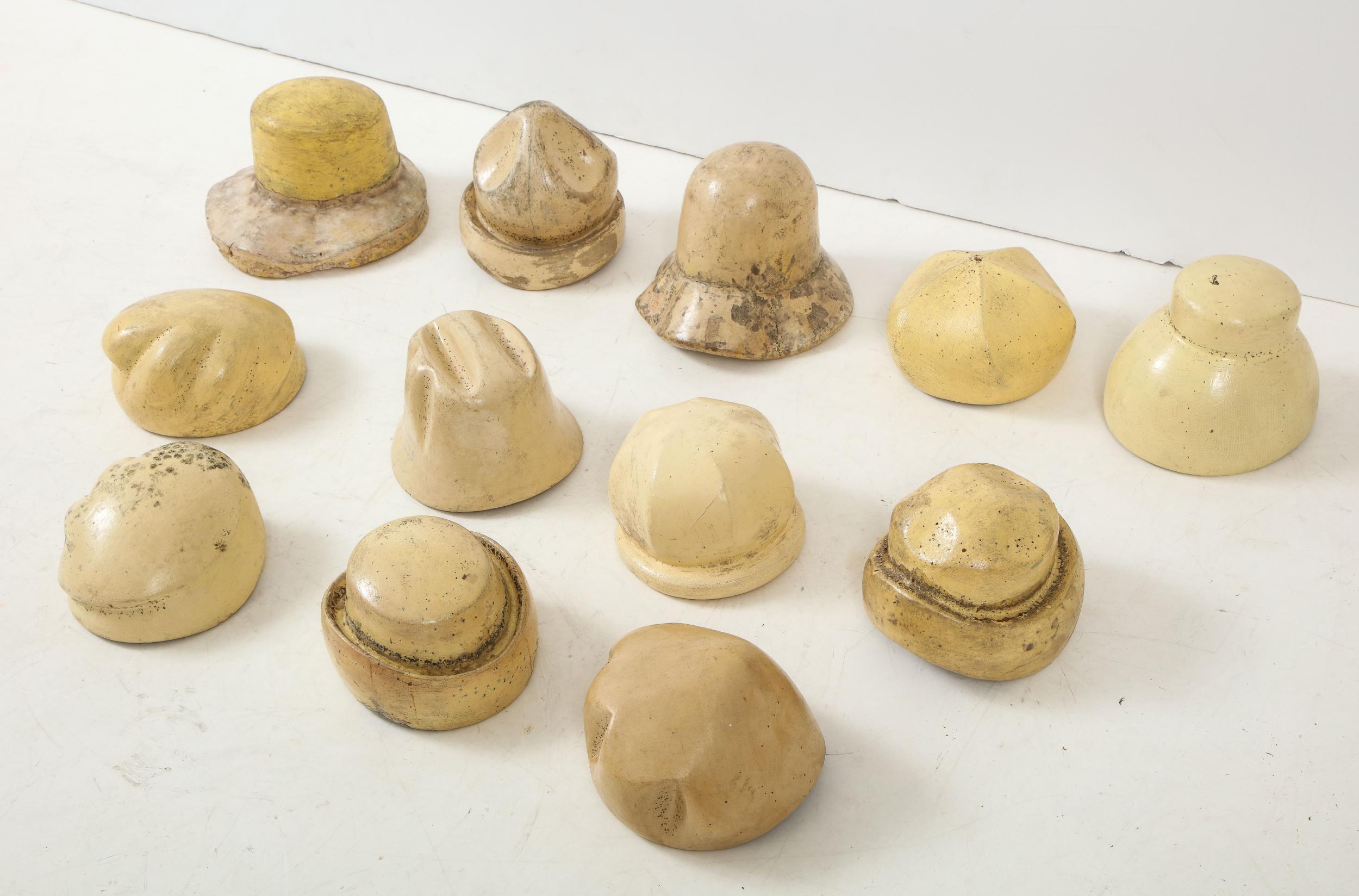 Set of 12 vintage French wood hat molds. Twelve different styles of classic French headpieces from Ebra like a cloche, bowler, pillbox, and more. These authentic hat molds have wear consistent with pin placement during use. Early 20th century. The