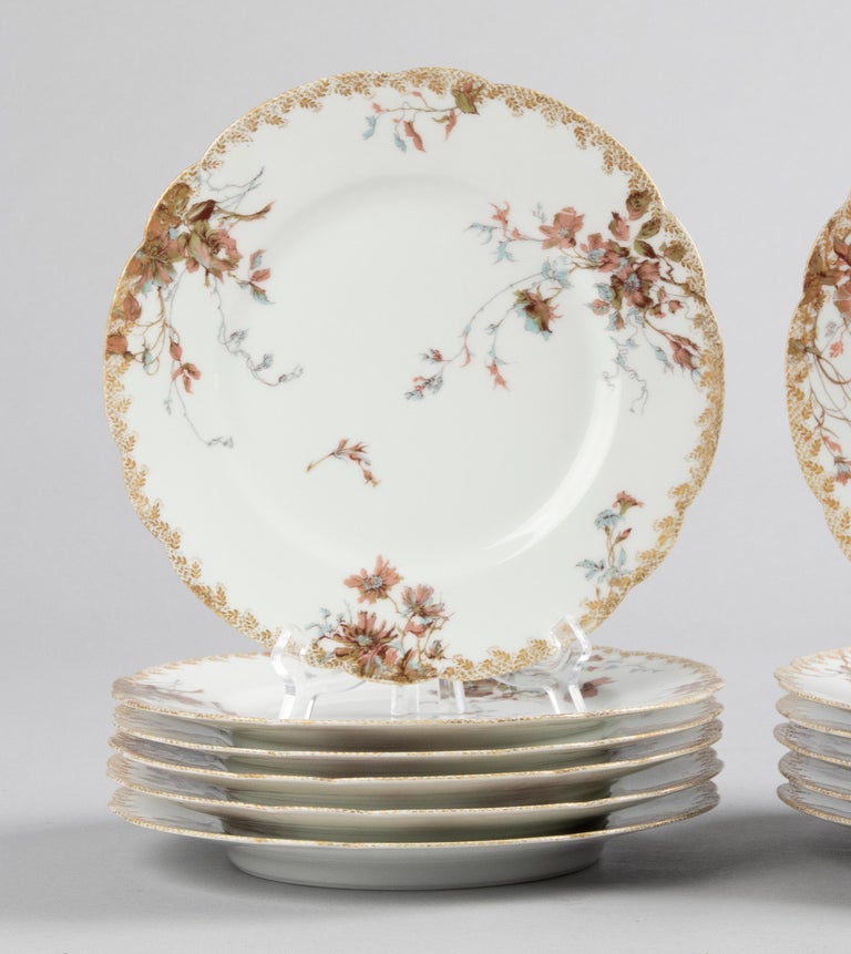 Beautiful set of 12 porcelain dinner plates by the French maker Haviland Limoges. The porcelain is decorated with all kinds of different flowers and gold-coloured accents in typical Art Nouveau style. Beautiful gilding on the edges. The plates are