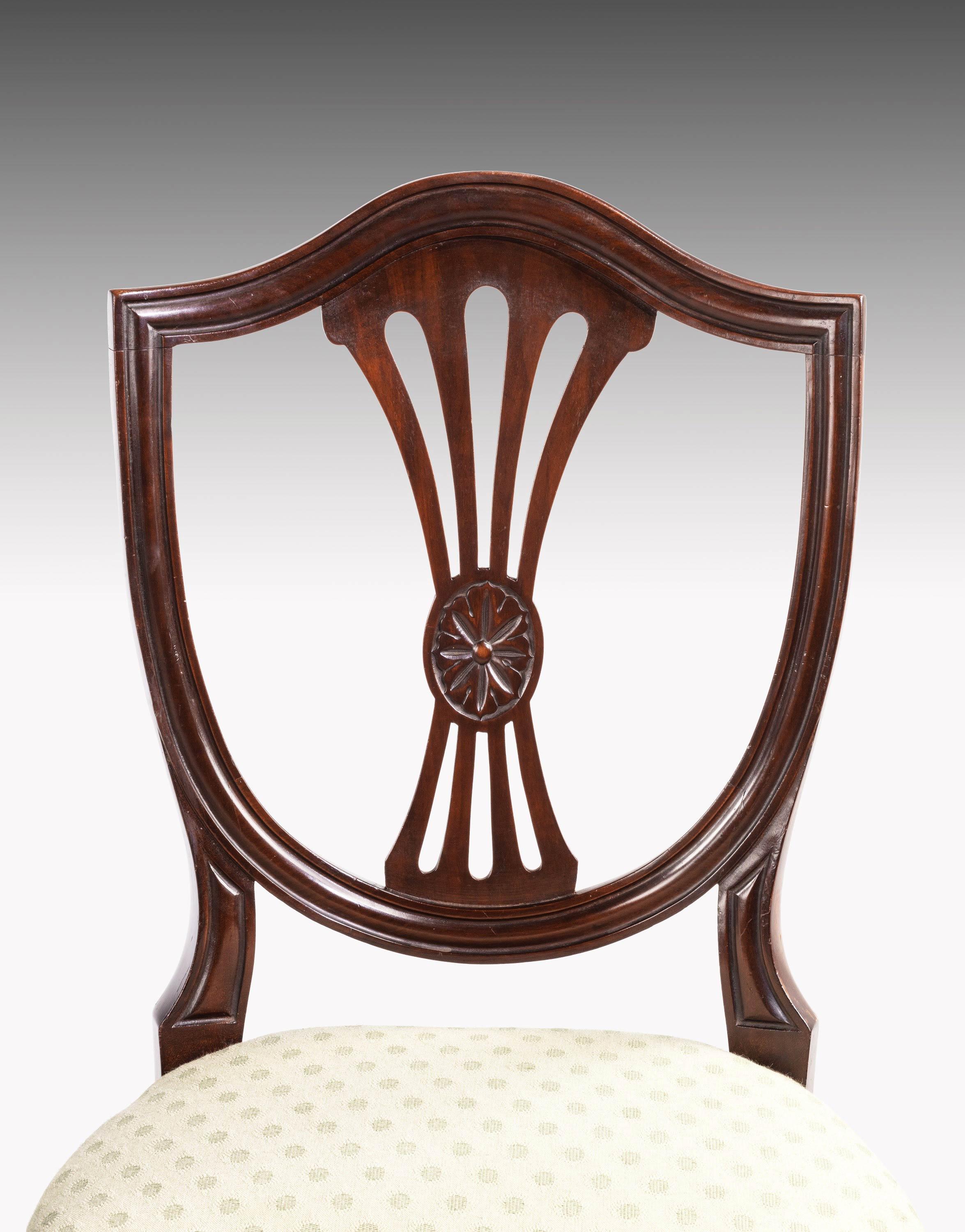 A good and sturdy set of 12 (10+2) Hepplewhite style mahogany dining chairs. Very well constructed with fine timbers. The pierced, shield shaped backs over tapering square section supports ending in spayed toes.
 