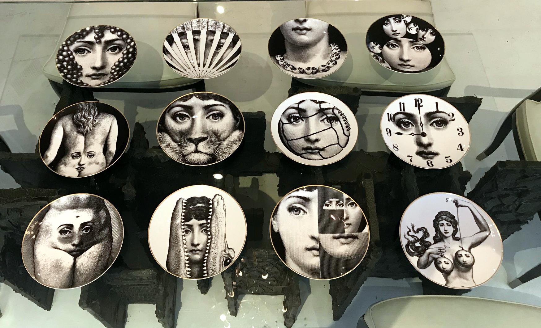 A large set of 12 displaying porcelain plates with surrealism designs by Piero Fornasetti for Rosenthal, an iconic series from 'Temi e variazioni' (“Themes and Variations”). These plates were made for displaying on the wall as well as daily use and