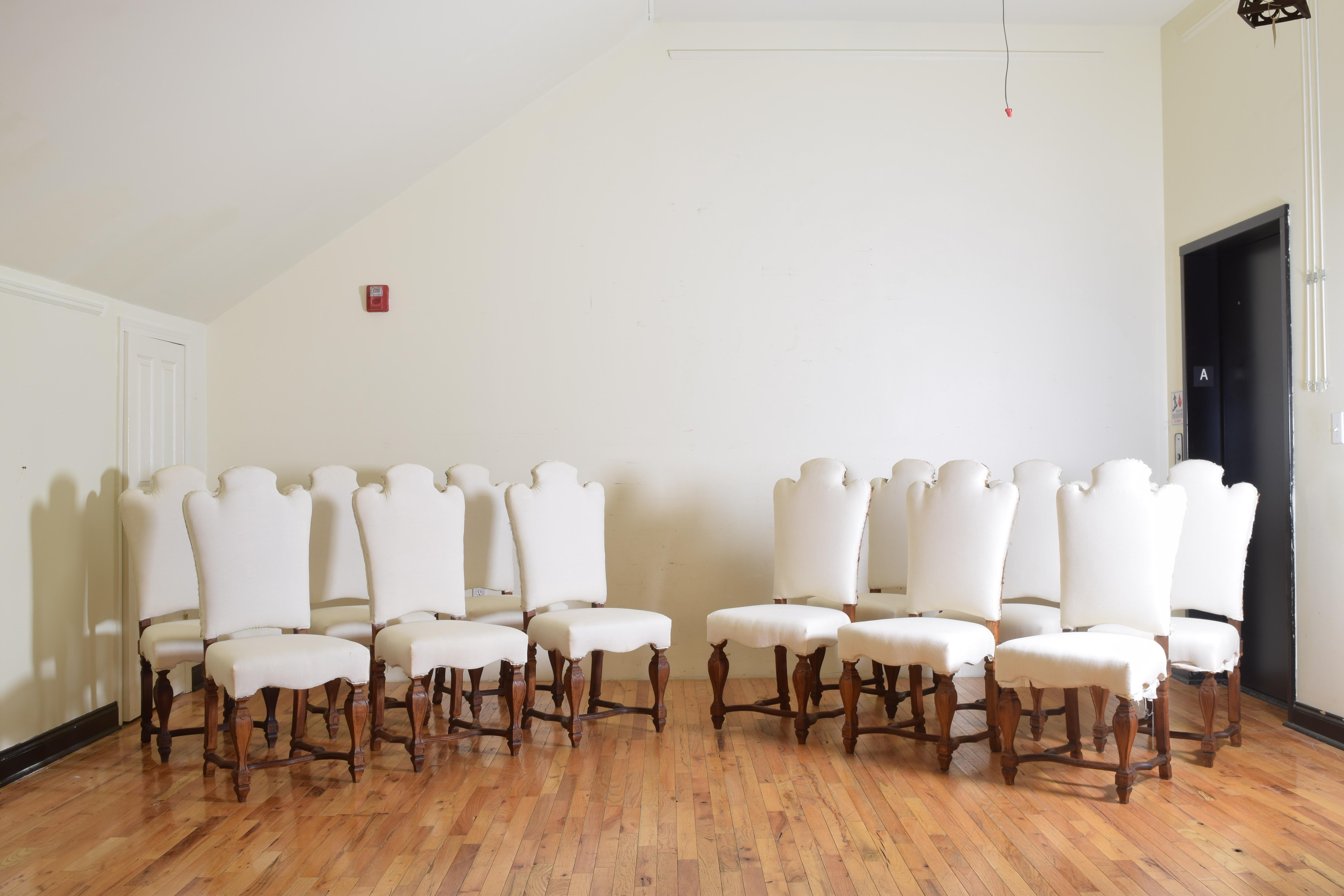 Each chair having a shaped and arched backrest atop a fitted seat with shaped apron and raised on shaped tapering legs joined by a carved h-form stretcher.