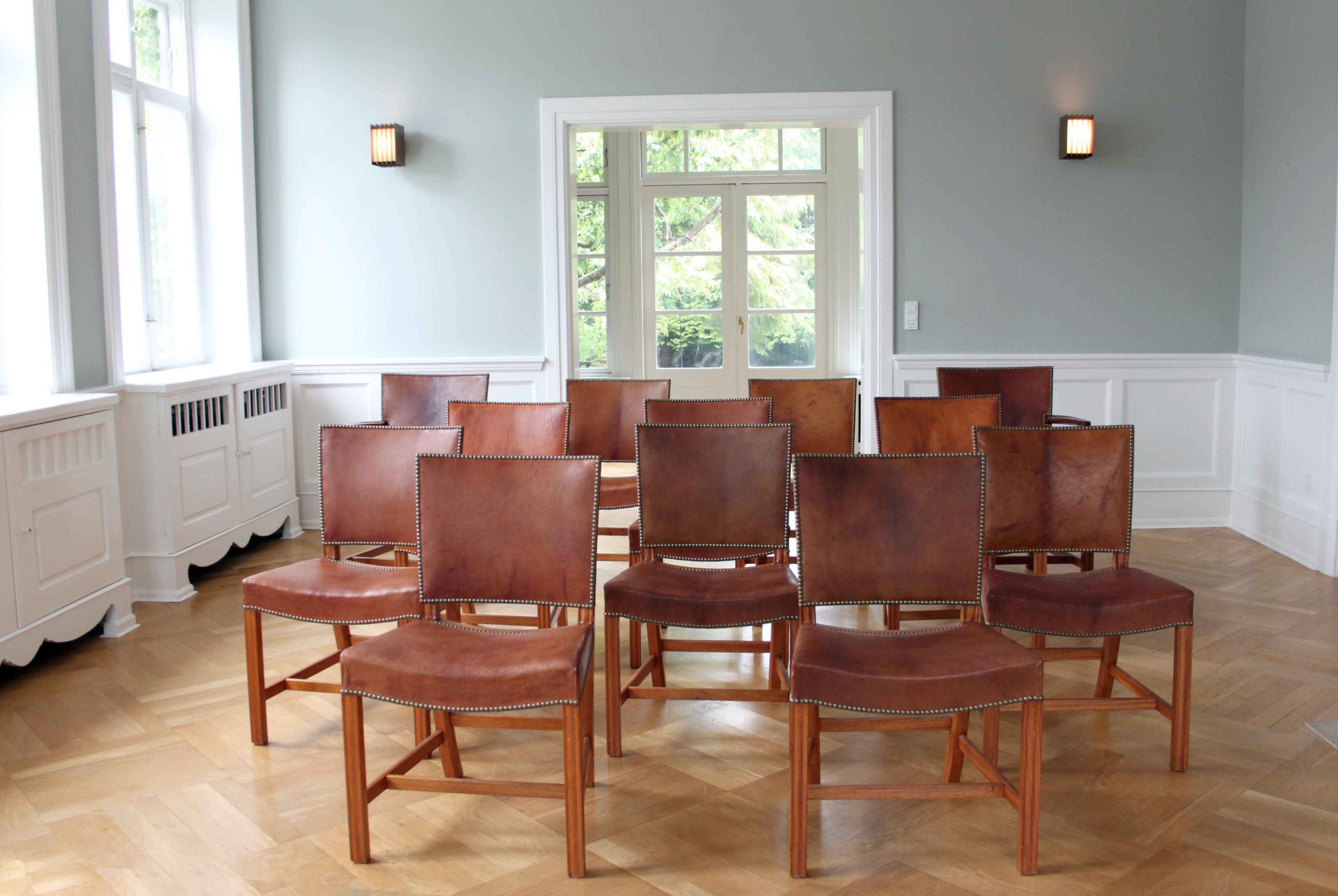 Kaare Klint & Rud Rasmussen Snedkerier - The Modern Scandinavian Design.

Un ensemble extraordinaire de douze chaises rouges Kaare Klint, exécutées par l'ébéniste Rud. Rasmussen, Danemark.

Pieds profilés en acajou, assise et dossier garnis de cuir