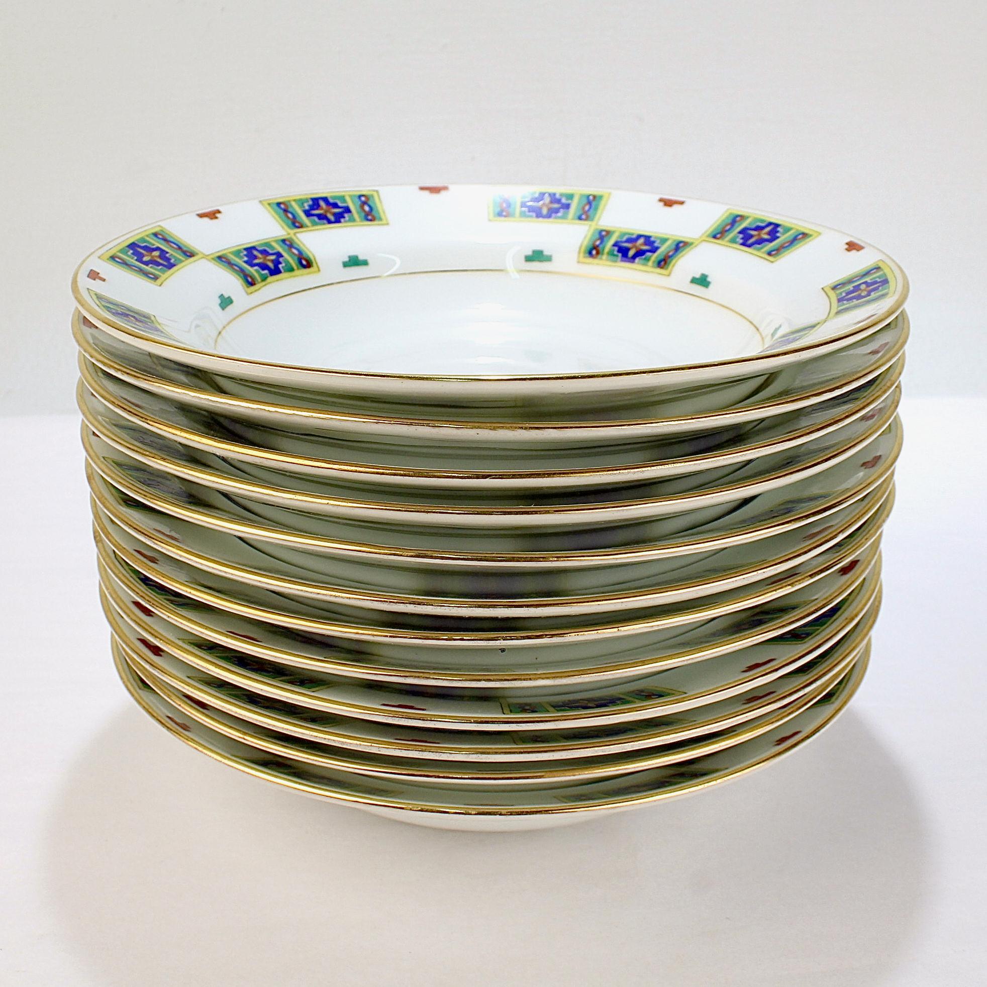 A fine complete set of 12 antique Russian porcelain soup bowls.

By the Russian porcelain manufacturer - Kornilov Brothers.

With green, yellow, blue, and red enamel decoration to the border, as well as gilt highlights.

Originally retailed by
