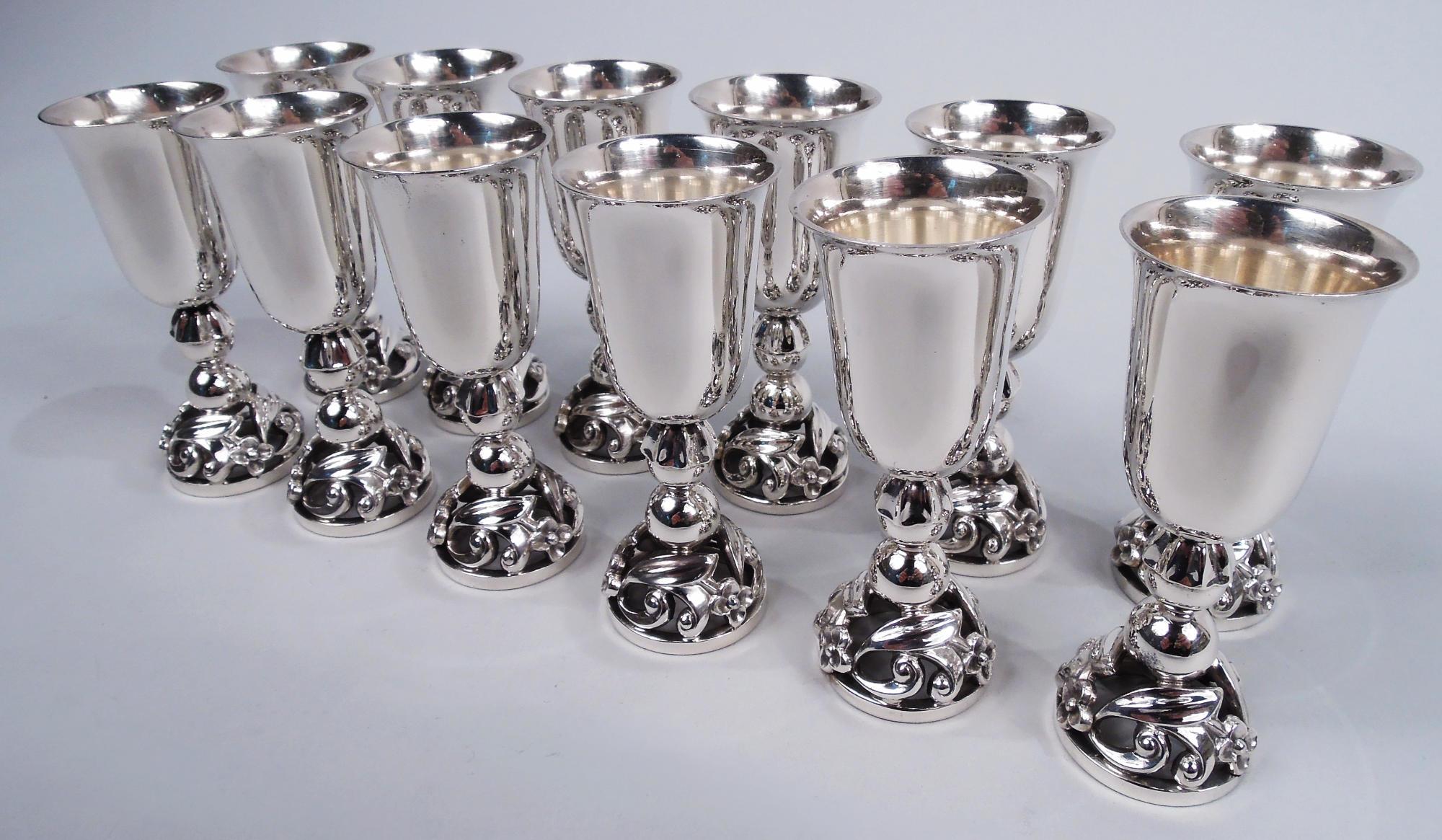 Set of 12 Midcentury Modern sterling silver cordials. Made by Alphonse La Paglia (d. 1953) in New Jersey. Each: Tall and tapering bowl with flared rim and curved bottom; double bead support set in leaf mount and open domed foot with cast leaves and