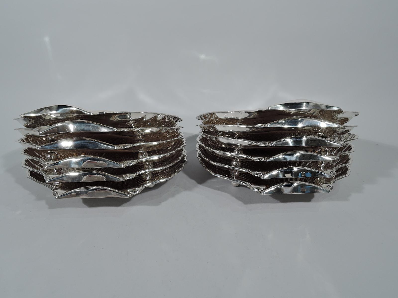 Set of 12 sterling silver scallop shells. Made by Gorham in Providence. Each: Dense and tiered flutes, sloping well, and two ball supports. All hallmarks include pattern no. 40617 (one has pattern no. 40617/1). Eight have date letters from
