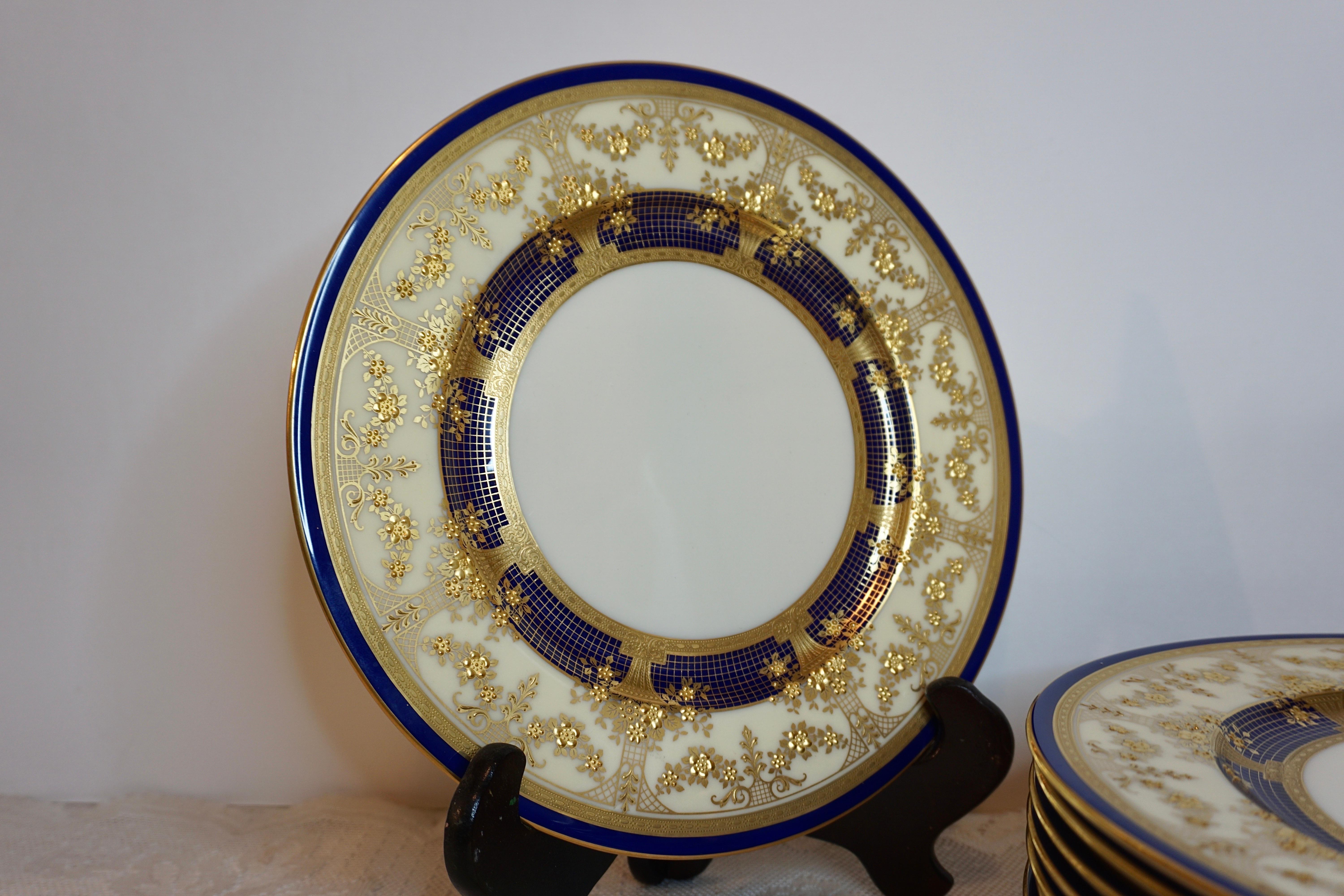 This is a gorgeous set of twelve antique Lenox dinner plates from the 1920s-1930s. They are decorated with profuse raised gilding with garlands of flowers and baskets of flowers. Lenox made them exclusively for Tilden Thurber Corporation in