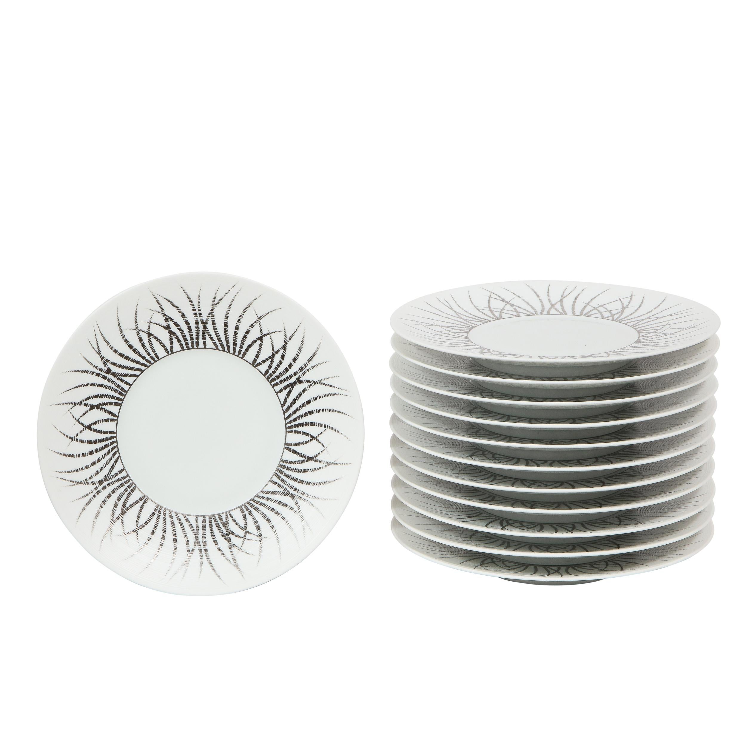 Este elegante juego de doce (12) platos de postre fue realizado por el estimado fabricante J.L. Coquet de Limoges, Francia. Presentan cuerpos circulares de porcelana con centros blancos lustrosos y perímetros mates estriados con detalles dorados