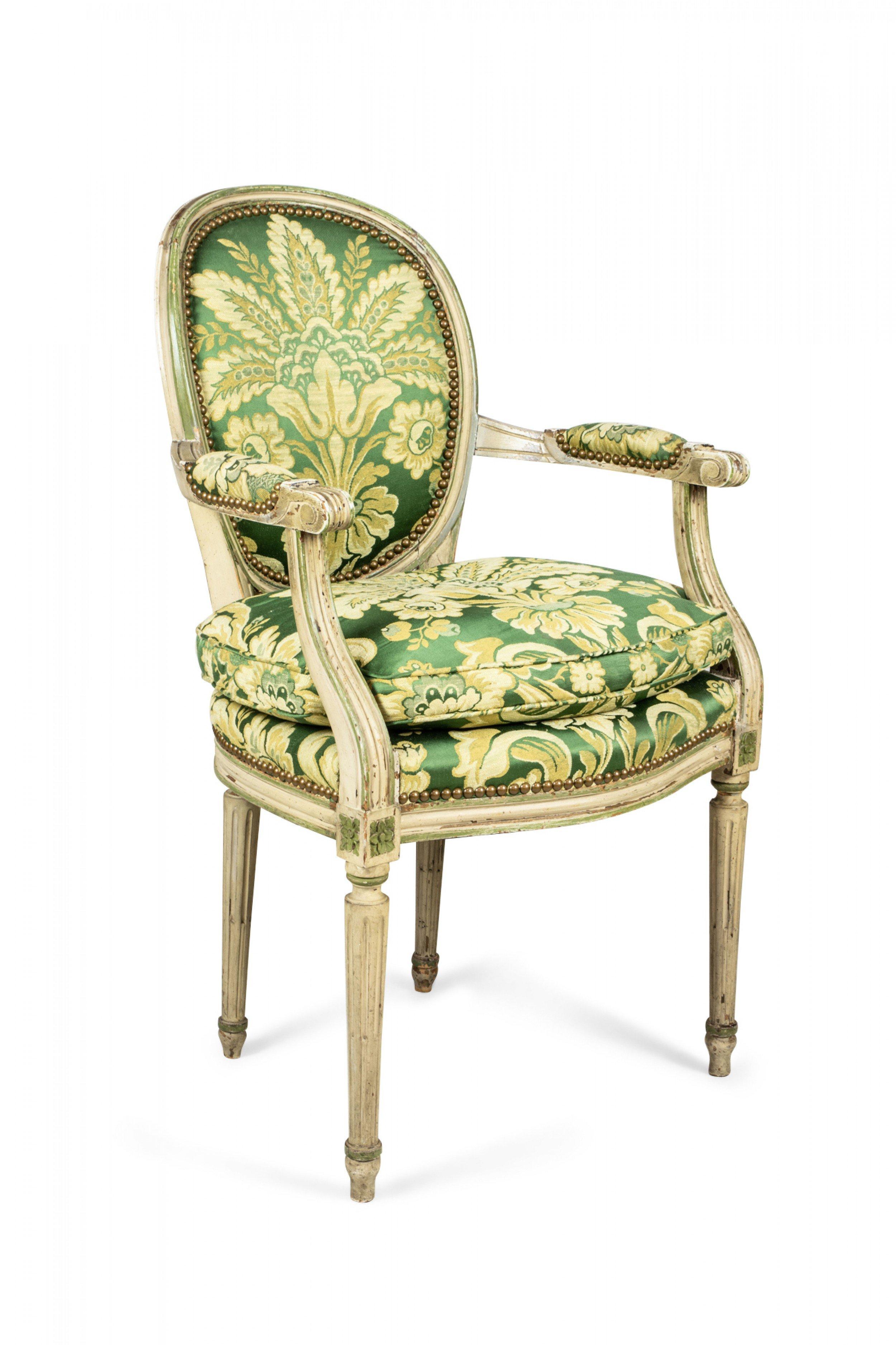 Set of 12 Louis XVI-style (1st half 20th Century) dining chairs with off-white painted frames with green trim and having oval channeled backs, upholstered in green and gold silk damask and raised on 4 tapered and fluted legs (2 of the side chairs