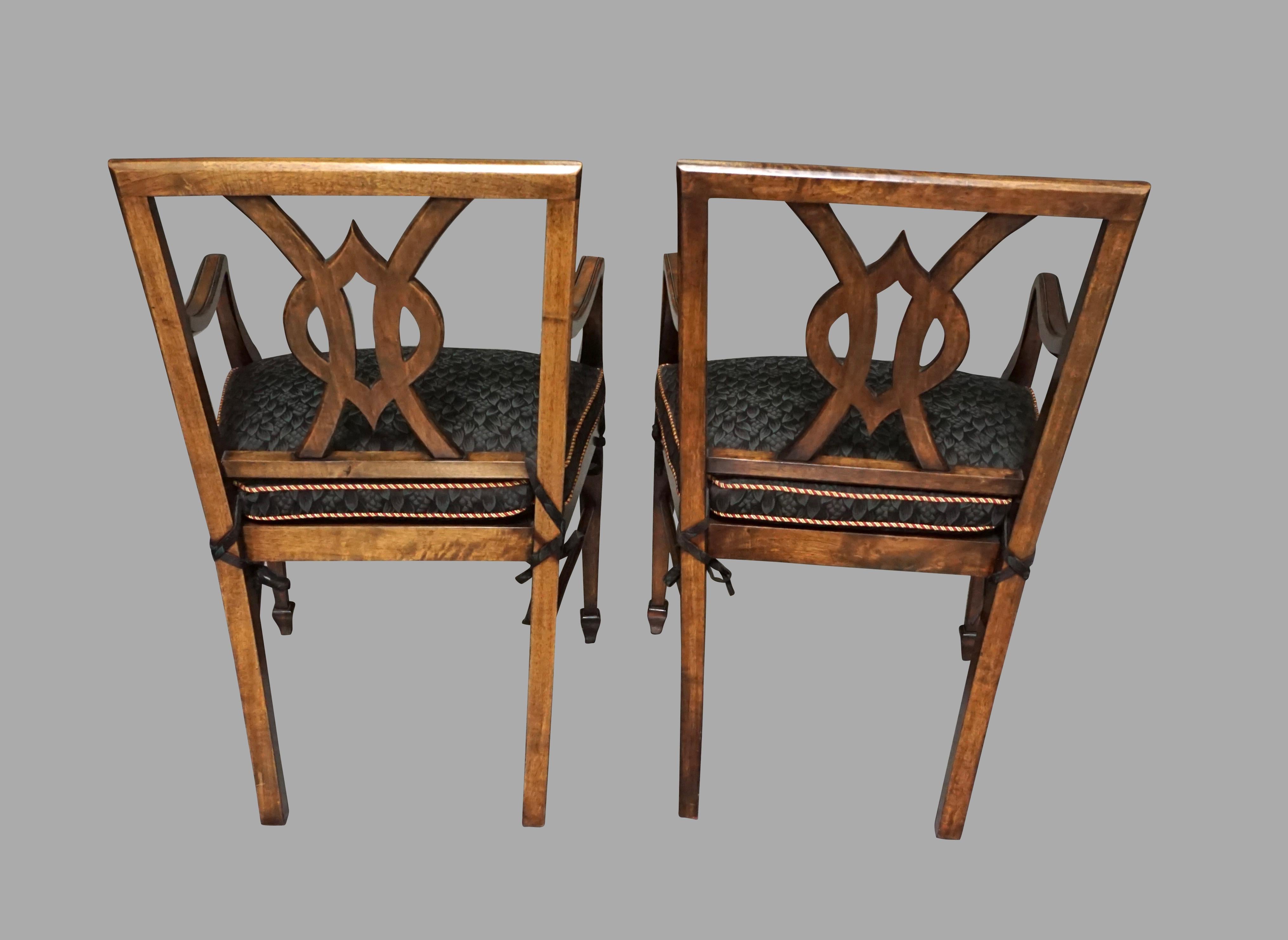 An attractive set of 12 custom designed serpentine mahogany dining chairs consisting of 10 side and 2 arm chairs in the neoclassical taste, each chair with an interlaced splat framed by straight stiles resting on square tapered legs, joined by