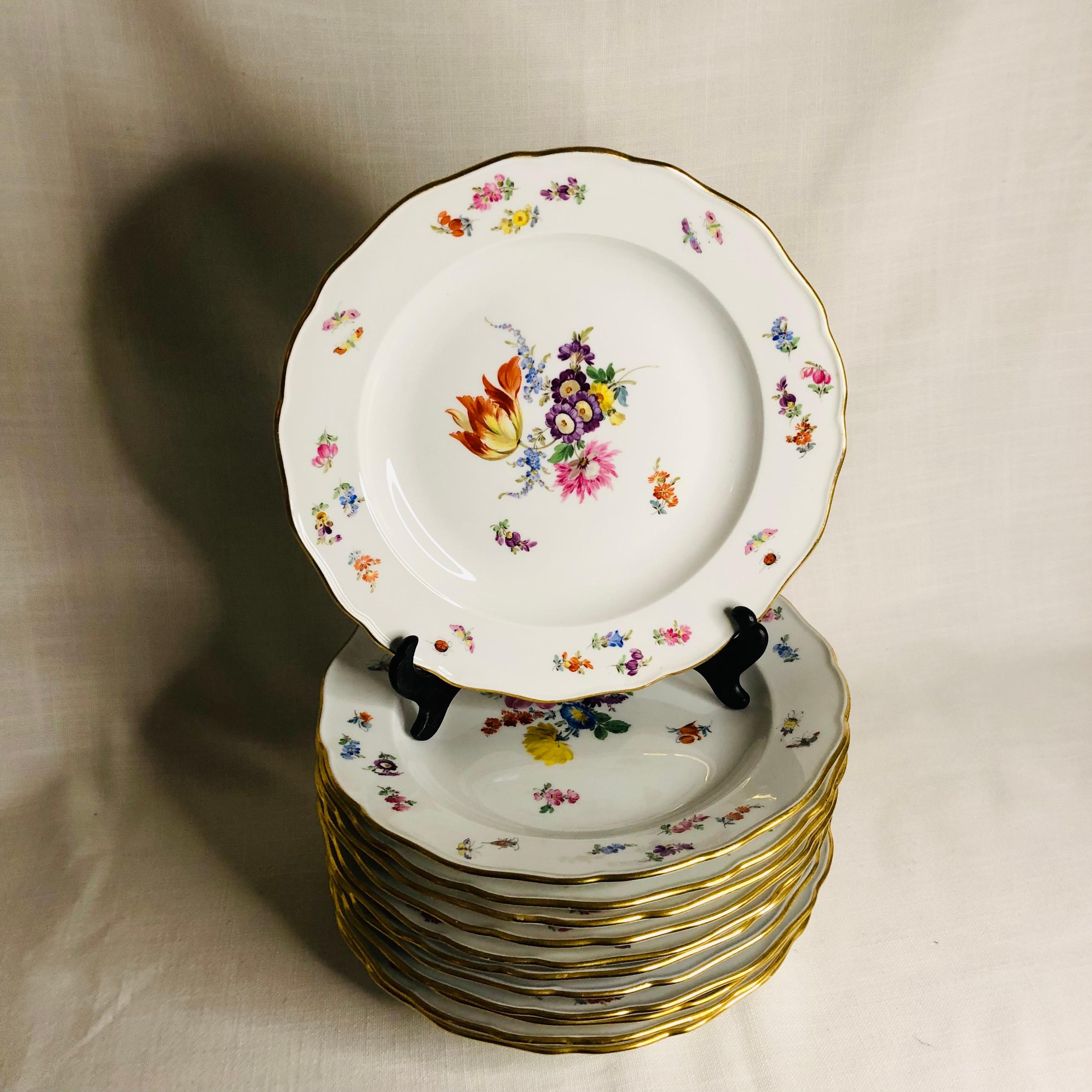 This is a fabulous set of twelve Meissen dinner plates. Each of these Meissen dinner plates are beautifully painted with a different large central flower bouquet. The artwork on these plates is exceptional. Inside the gold border, you. can see