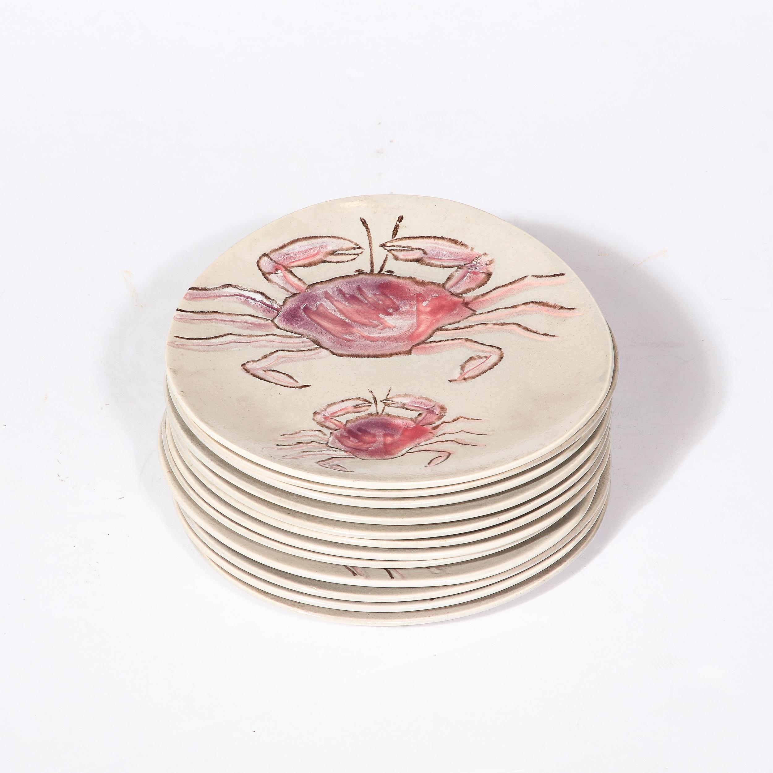 Ce charmant ensemble de douze assiettes modernistes du milieu du siècle en céramique peinte à la main par MBFA Pornic provient de France, vers 1960. Whiting présente une belle variété de créatures marines dans une gamme étonnante de teintes mauves