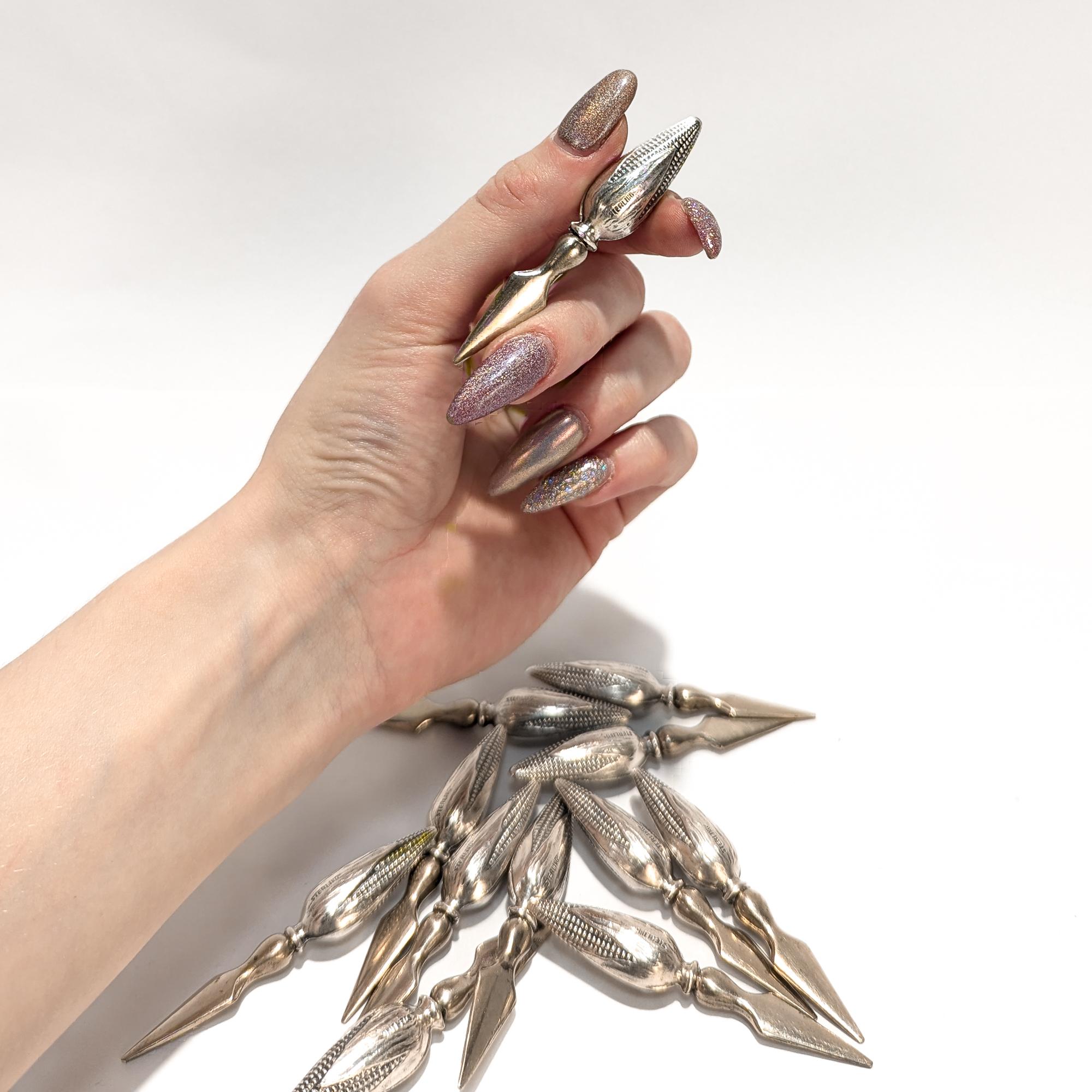 A fine set of 12 silver corn holders.

In sterling silver. 

The handles in the form of corn with the husks still on. 

The spear tips are either stainless steel or silver plated.

Marked to the handles.

Simply wonderful, whimsical design!

Date:
