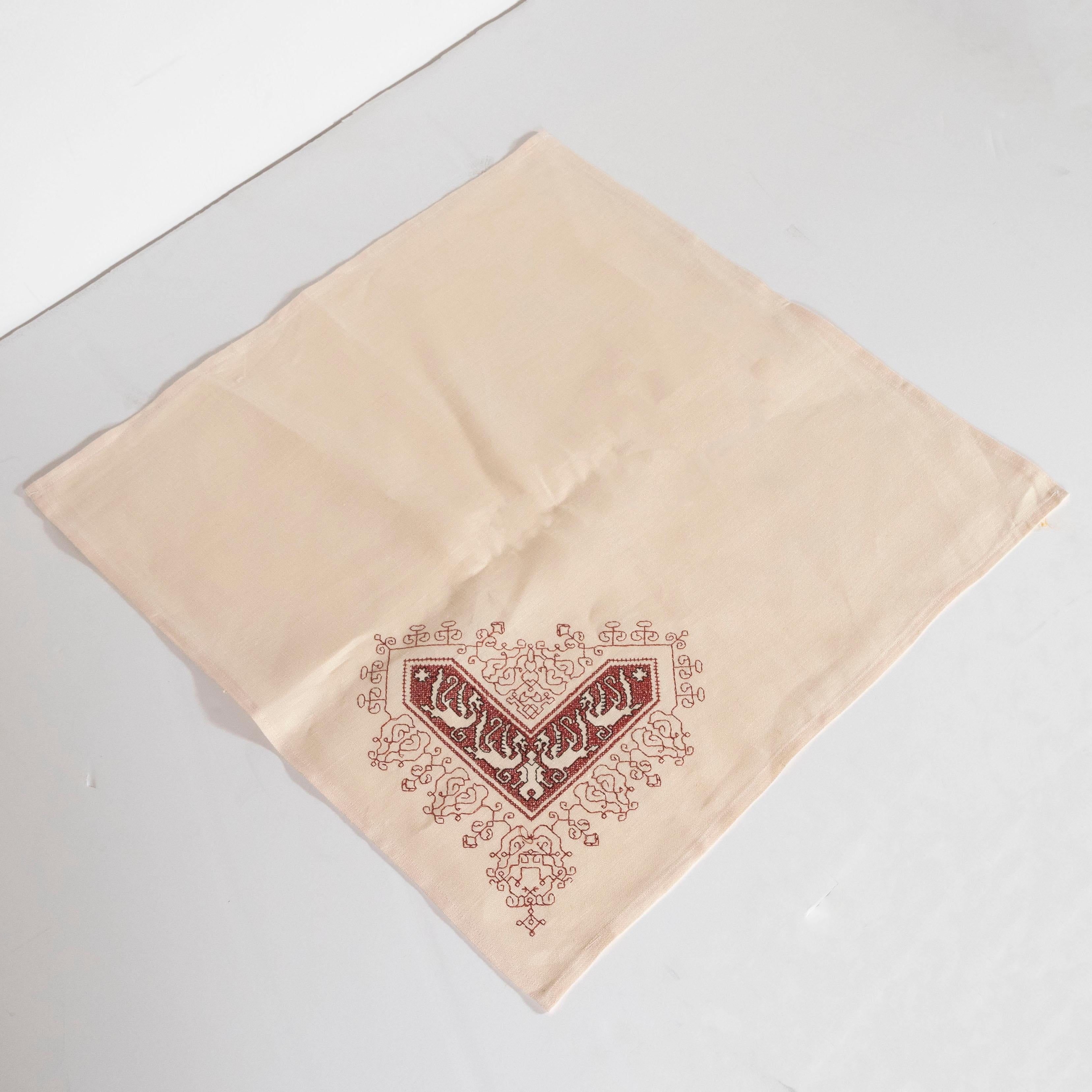 This beautiful set of twelve napkins were realized in Morocco in Northern Africa. They feature hand embroidery in pale crimson with black accents depicting stylized gargoyles, suggesting dragons, on ecru linen. Elegant, casual and beautifully