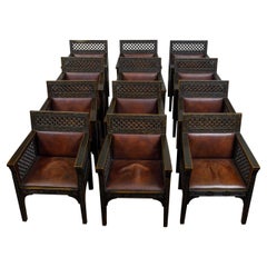 Ensemble de 12 fauteuils marocains en bois sculpté et ébonisé avec sièges en cuir, vers 1900