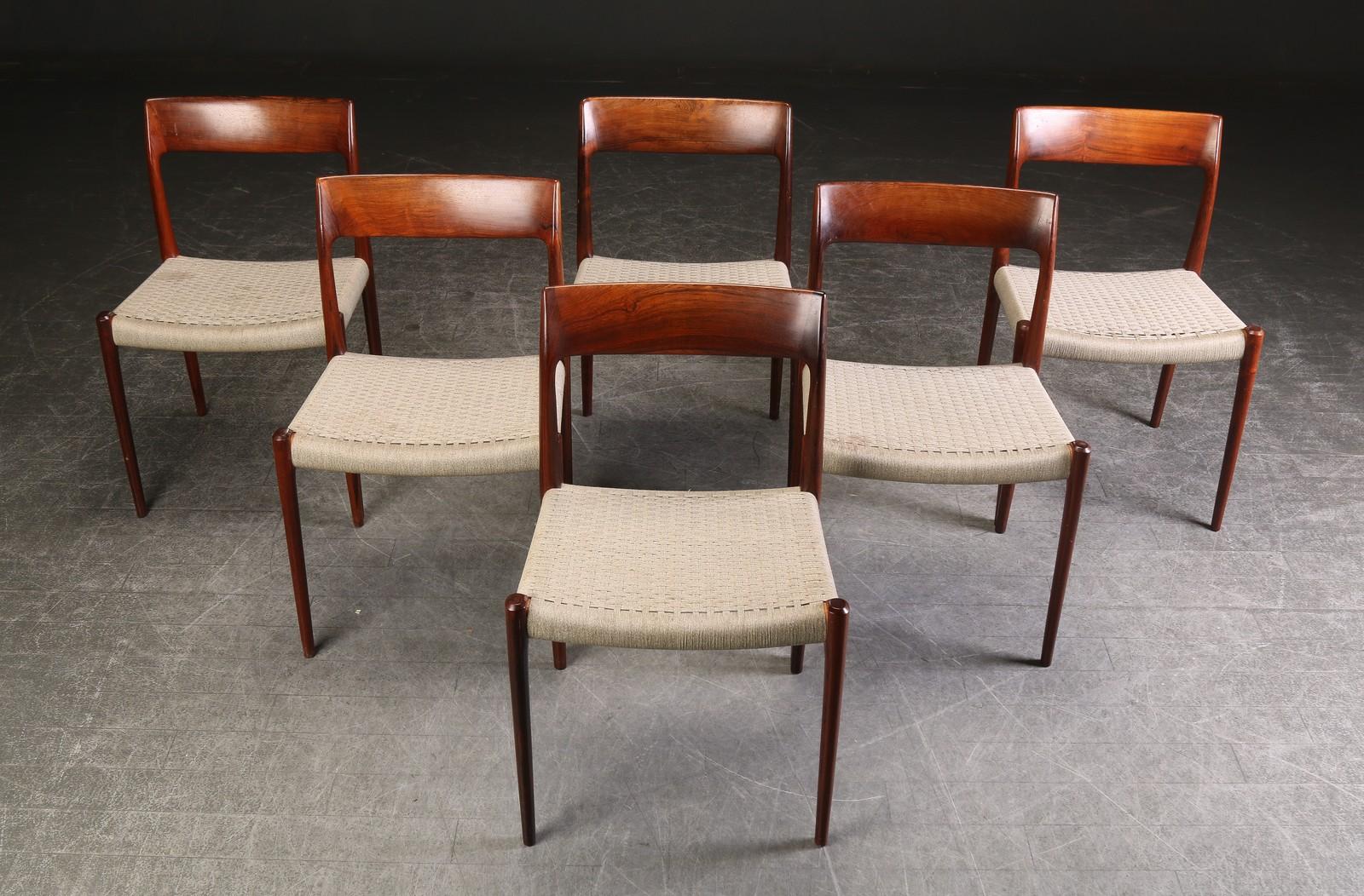 Dieser Satz von zwölf Esszimmerstühlen von Niels Otto Moller mit Sitzflächen aus gewebter grauer Wolle besteht aus zwei Sätzen von je sechs Stühlen. Das runde Label datiert diese Stühle auf die Zeit zwischen 1958 und 1969. 

Die graue, gewebte