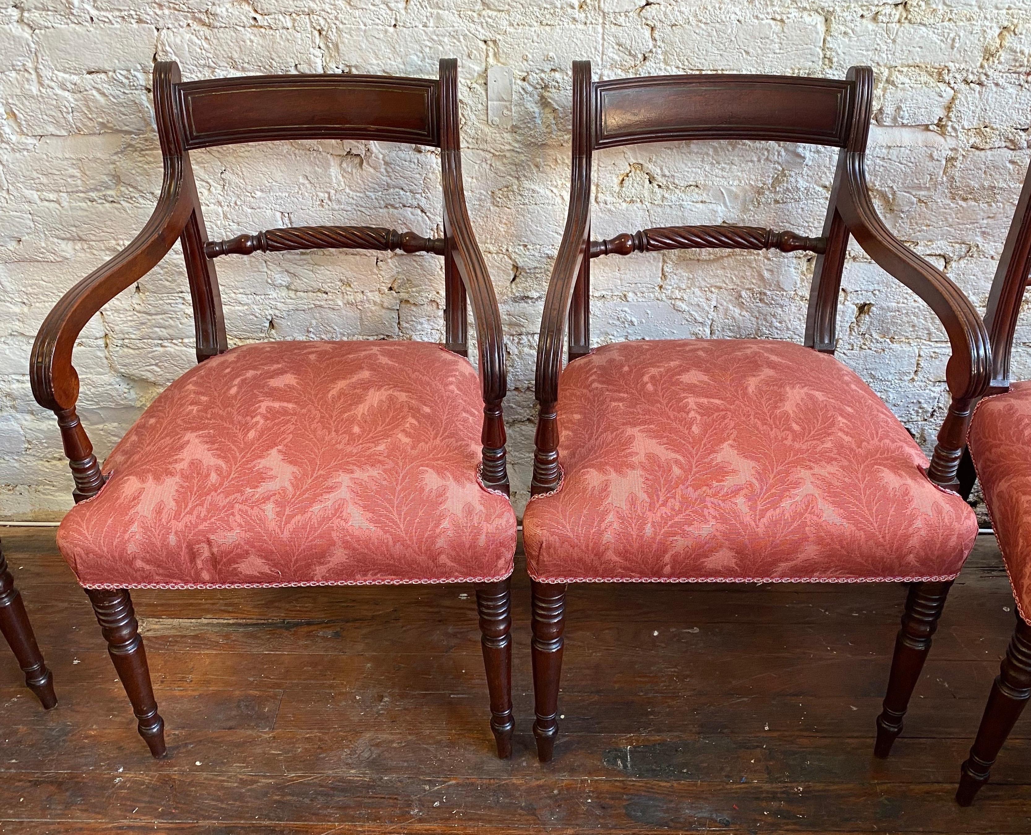 Great set of 12 periods 19th century English Regency mahogany dining chairs in an attractive upholstery. Chairs are hand carved mahogany with brass inlaid in to the backs.

10 side chairs measuring 34