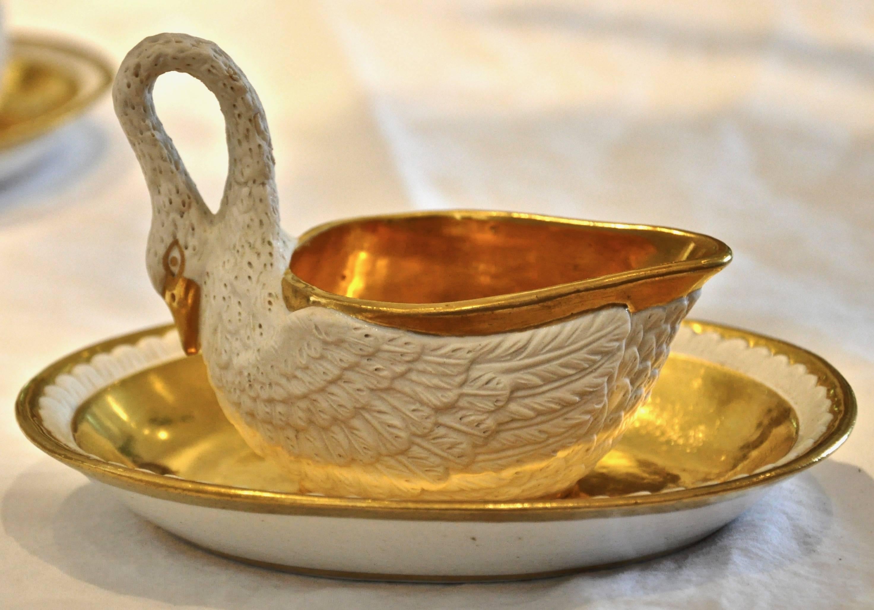 Set of twelve period empire early 19th century bisque and gilt swan cups

- Each modeled as a naturalistic swan in bisque porcelain and fire gilt

- A set of 11 original empire swan cups and saucers and one additional later, variant swan cup and