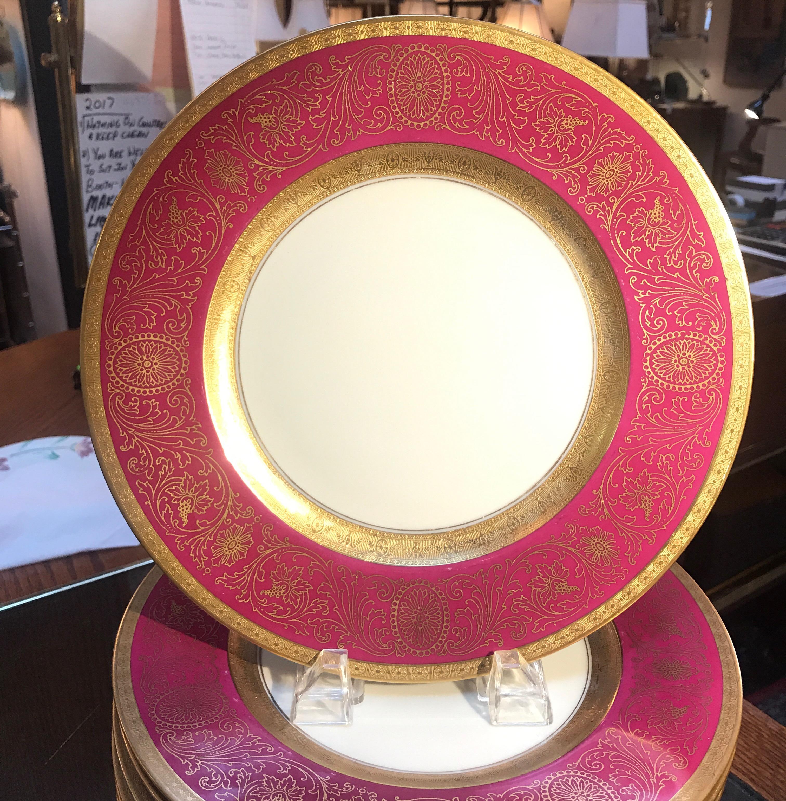 A set of 12 wide bordered service plates with fuchsia and gold borders. The porcelain plates made by Hutschenreuther and decorated by the Pickard. These plates are in excellent condition showing very minor stacking wear. 
The Pickard China story