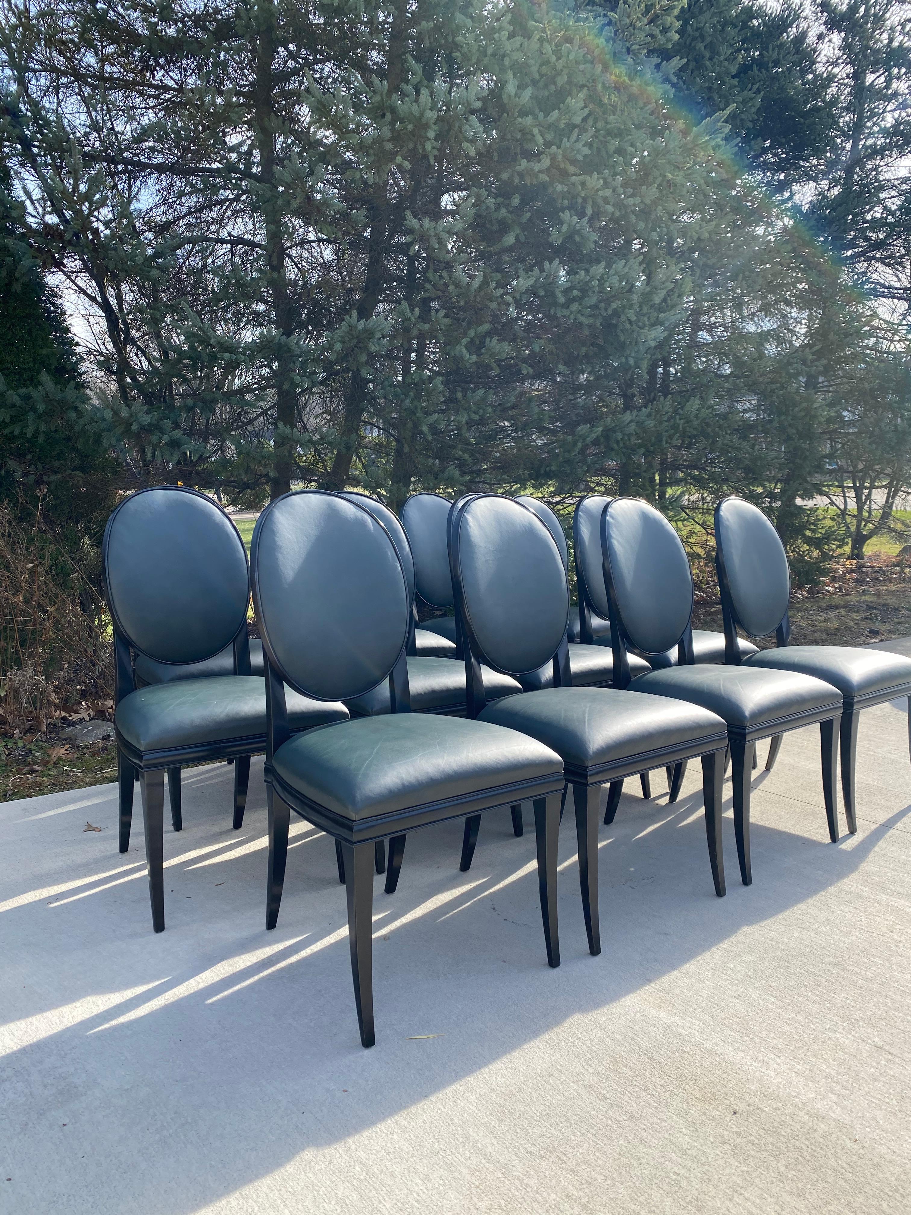 Set of 12 Randolph and Hein dining chairs in black lacquer and its original green leather fabric. These chairs do have some imperfections due to age, see pictures. The fabric does have some wear to it and should be reupholstered. This set was owned