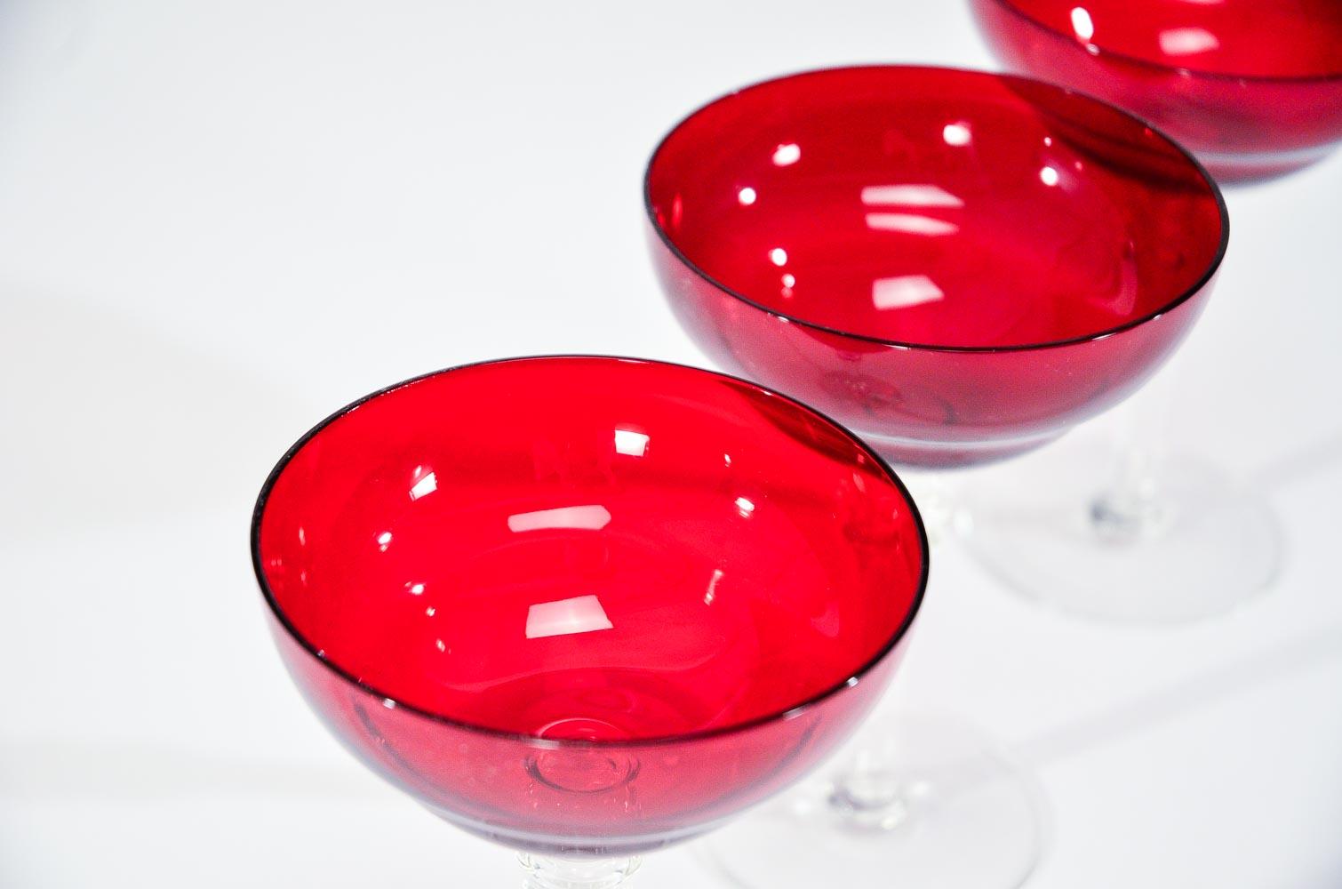 Dieses Set aus 12 Martini-/Champagnerbechern hat die perfekte Größe und Form für Ihren Lieblingscocktail, der in einem leuchtend rubinroten Glas serviert wird. Der gegossene, klare Stiel und die ungewöhnliche Form erinnern an die Zeit des Art déco