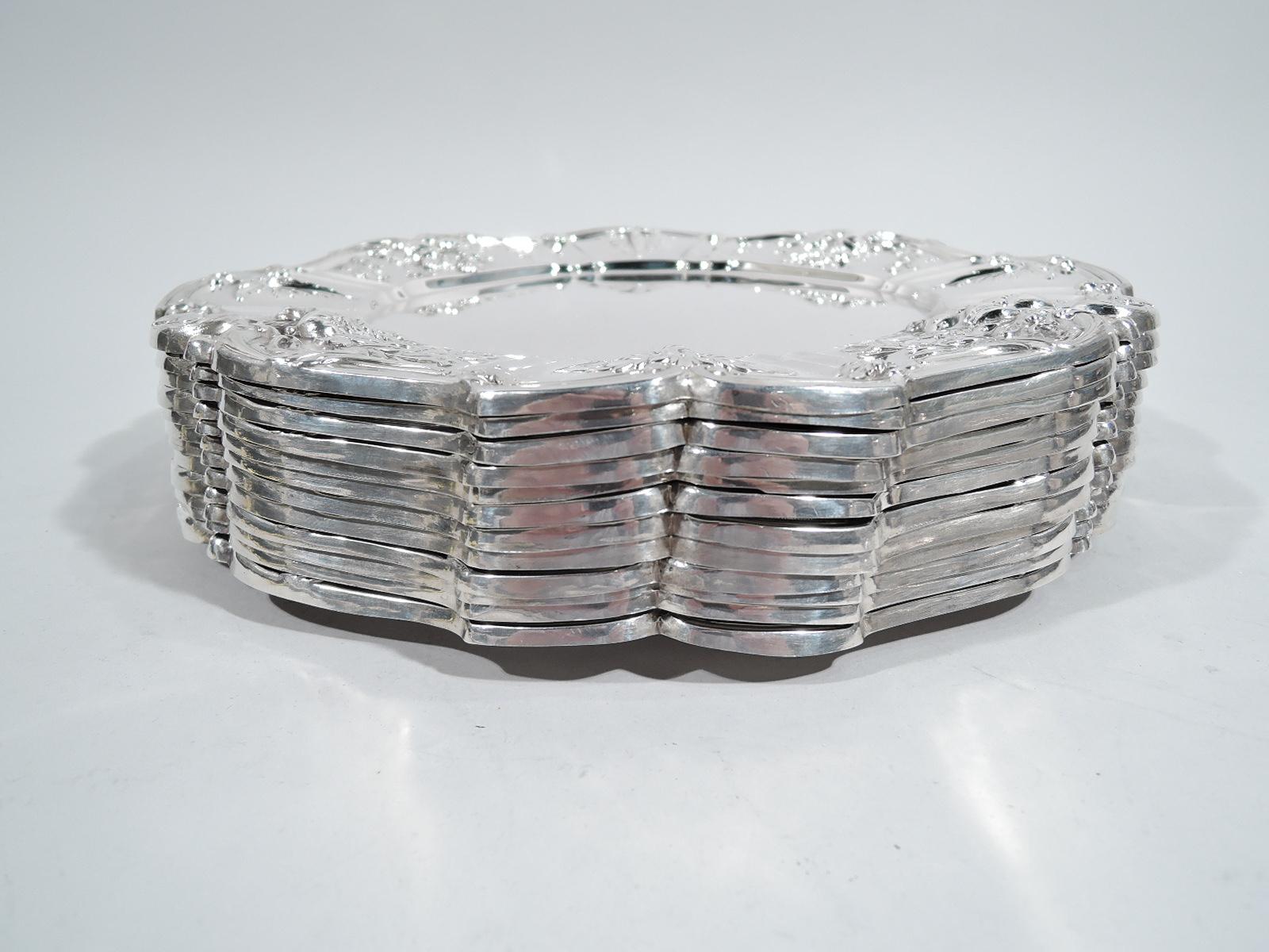 Twelve Francis I sterling silver dinner plates. Made by Reed & Barton in Taunton, Mass. Plain well and wide shoulder with chased vegetation and plants in alternating wide and narrow frames. Rim scrolled. A beautiful midcentury era set in the