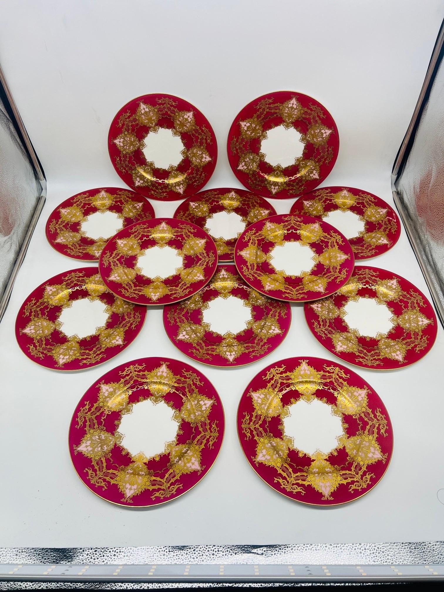 Set of 12 Royal Worcester Two- Tone Heavily Raised Gilt Decorated Dinner Plates.

Each plate intricately decorated with raised jeweled gilding accenting the fine 6 pink tone windows presented across the surface of the magenta base. The thorn vines