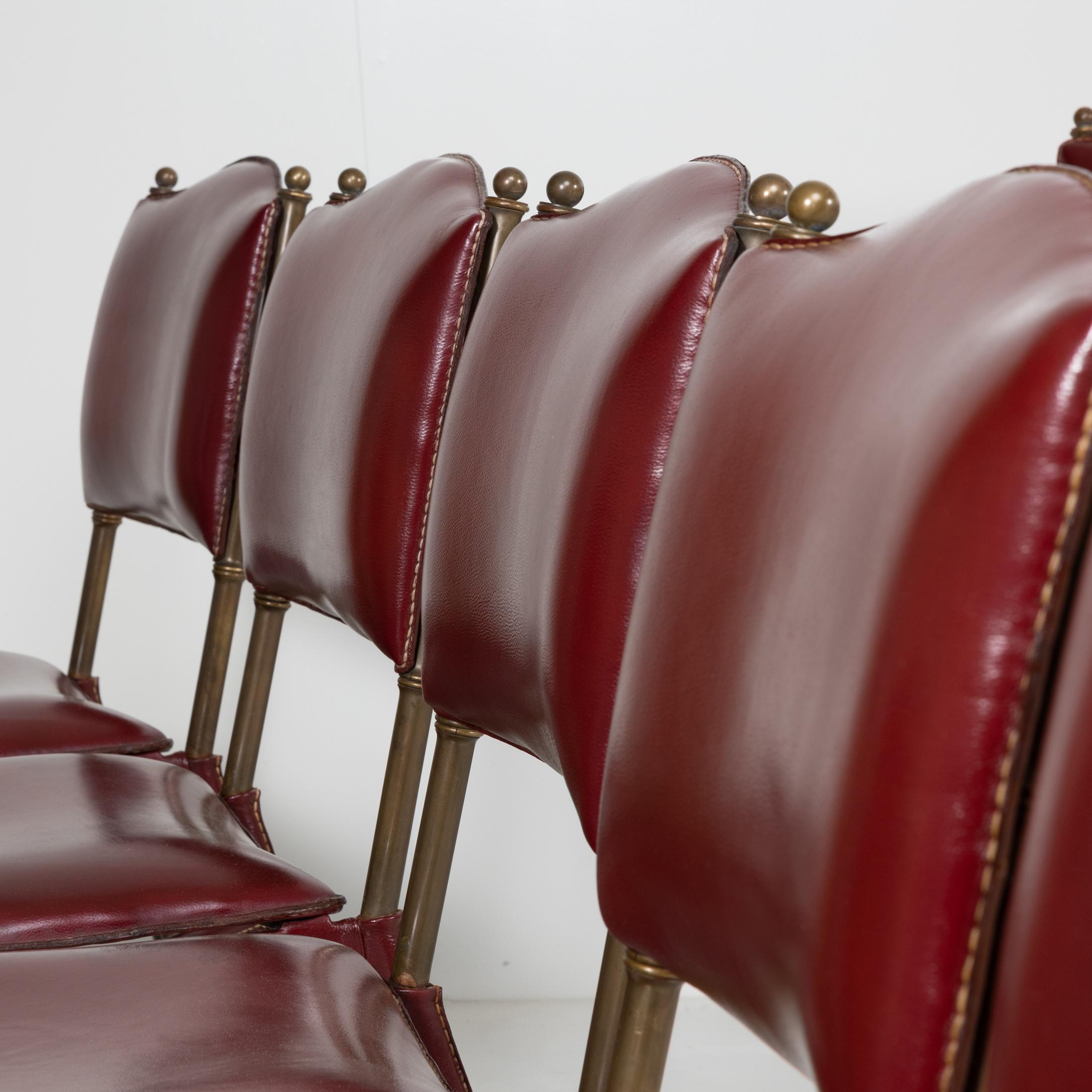 Satz von 12 Stühlen aus rotem Leder mit Sattelstich von Jacques Adnet, Frankreich (Französisch) im Angebot