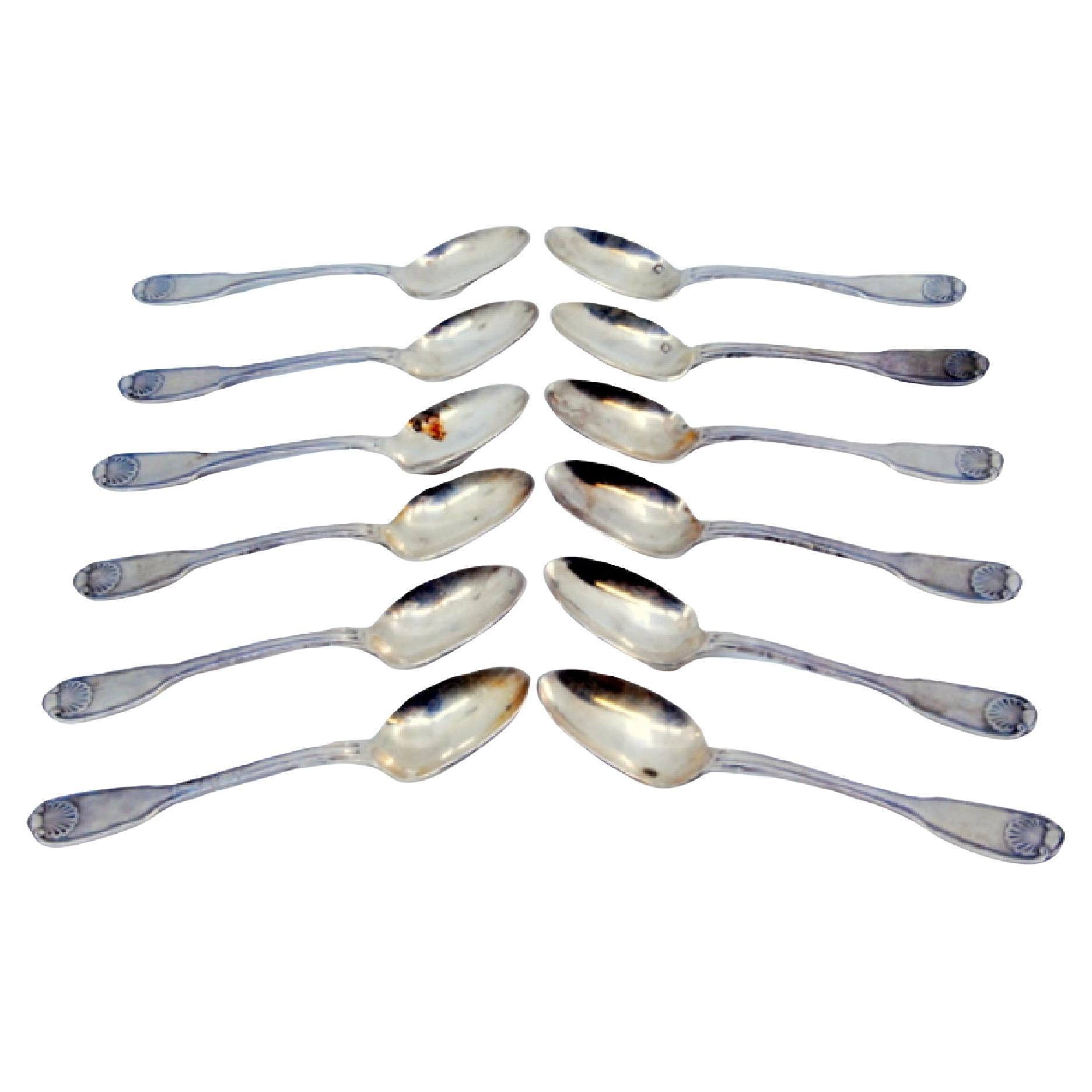 Set of 12 silver coffee spoons with shell-shaped relief handles For Sale