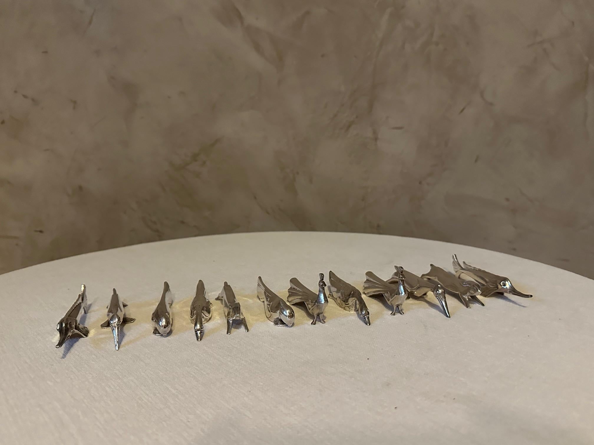Very nice set of 12 art deco knife holders in silver metal. 
This charming knife holder set was designed by Swiss artist Edouard Sandoz for Christofle. 
Each knife holder is silver plated and represents a different animal, from a hare to a peacock.