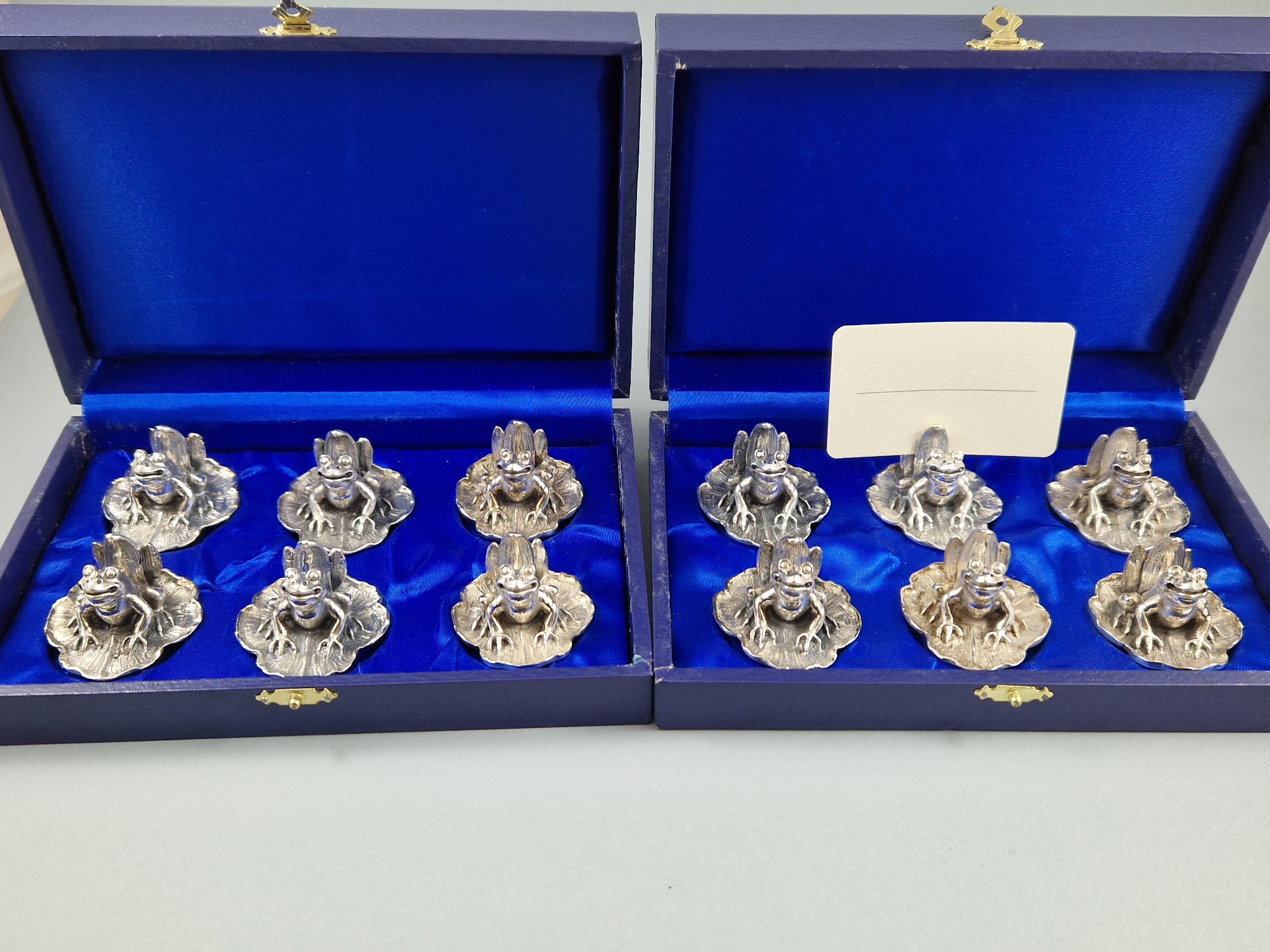 Rare and beautiful set of 12 place card holders in sterling silver 
In the shape of a frog resting on a water lily 

Italian work from the 20th century 
925 silver hallmark 
Measures: Height: 2.6 cm 
Diameter: 4.2 cm 
Weight: 452 grams.