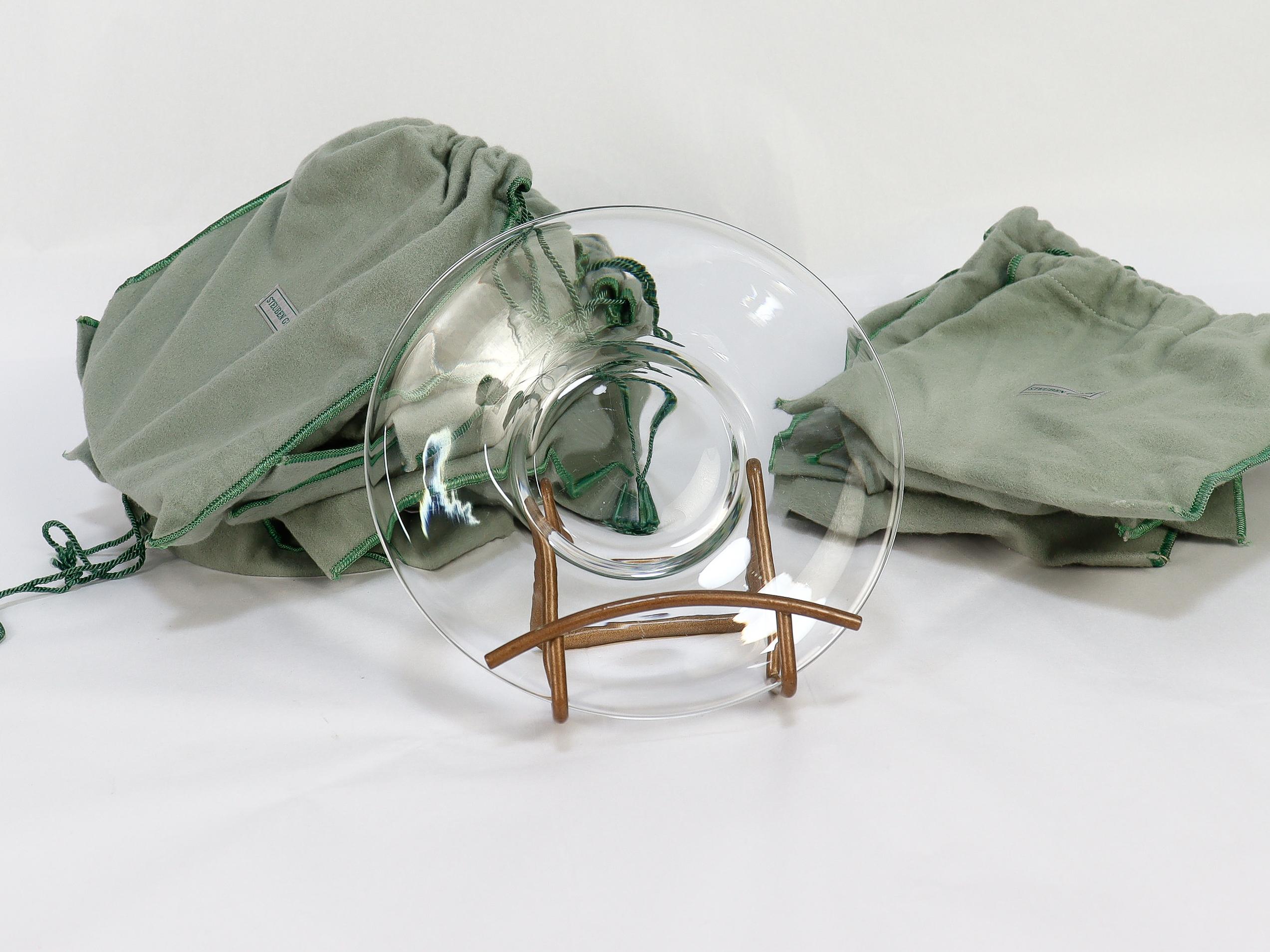 A fine set of glass plates. 

By Steuben.

In clear glass. 

Pattern No. 7644.

Each plate slightly recessed plate and with a thick foot. 

This set dates to the 1940s. Each marked to the underside with an etched 