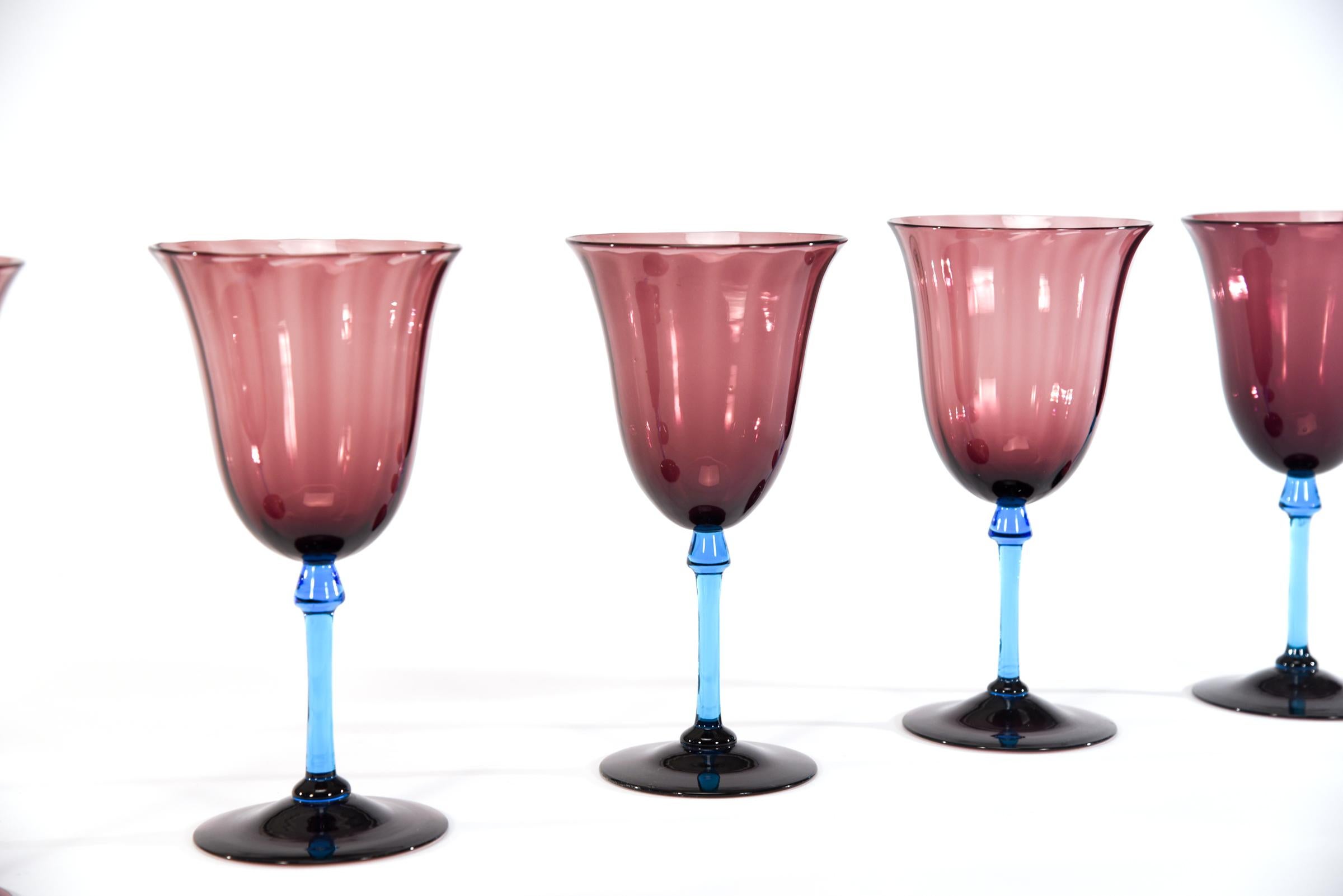 This is a rare set of 12 Steuben water goblets featuring hand blown amethyst optic ribbed bowls and foot and the amazing contrasting turquoise 