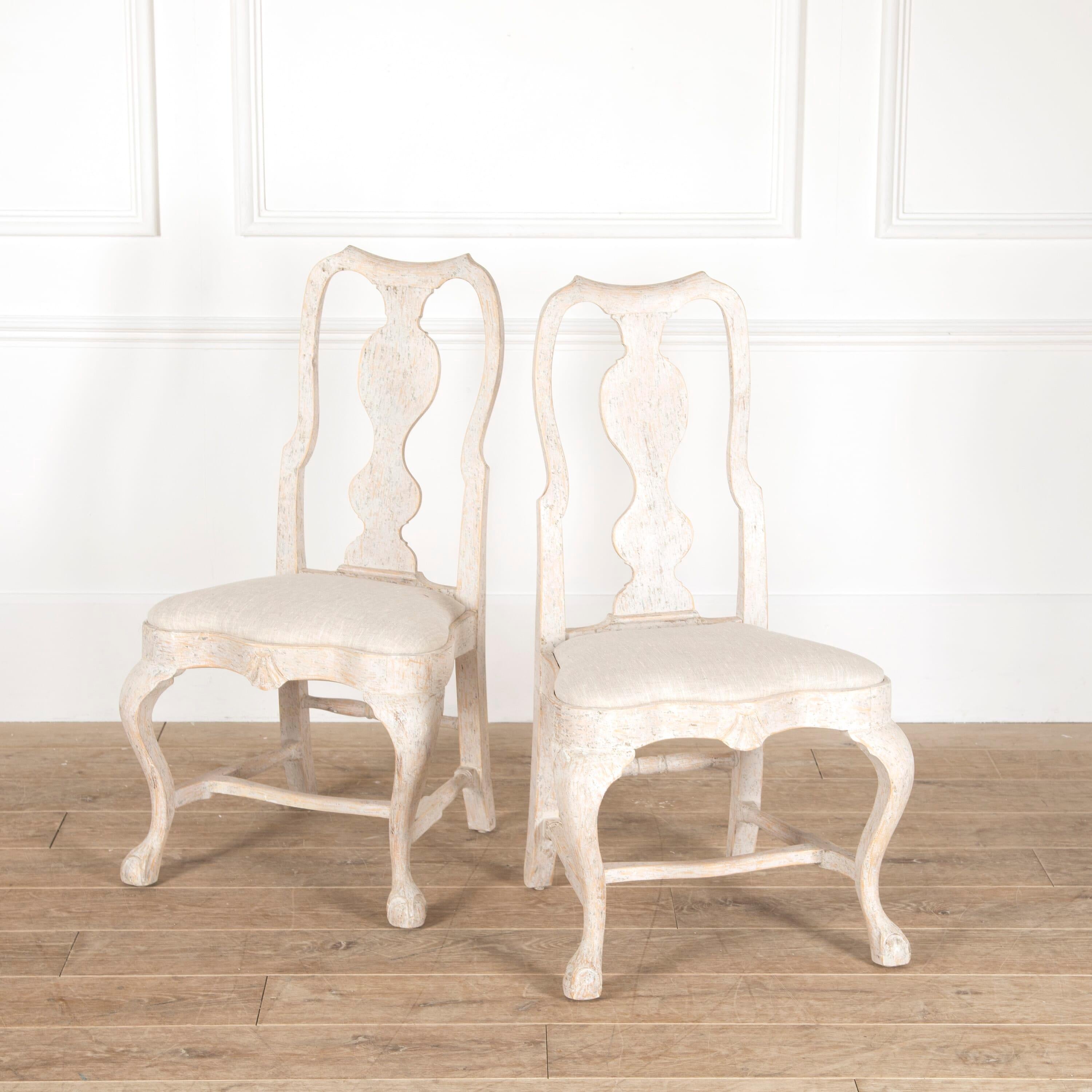 Set of 12 early 20th century Swedish Rococo style dining chairs. Circa 1920. 

These attractive chairs are armless with generous seats featuring a central carved shell motif to the apron. 

With undulating open backrests and a single central