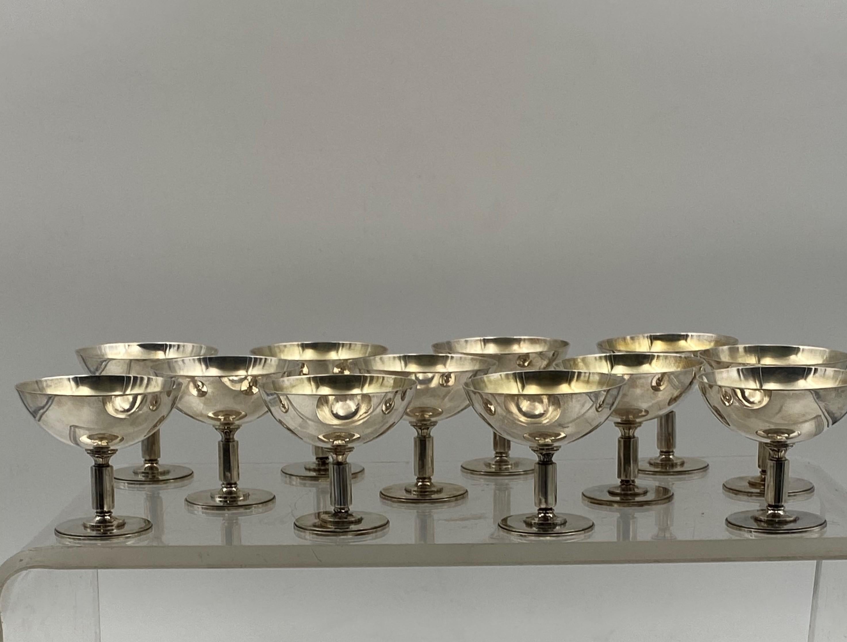 Set of 12 gilt wash bowls/Kiddush cups/champagnes/desserts by Swedish maker Borgila from the mid-20th century in Art Deco style with a palmette motif. They are reminiscent of the Pyramid style by famed maker Georg Jensen. They measure 2 7/8'' in