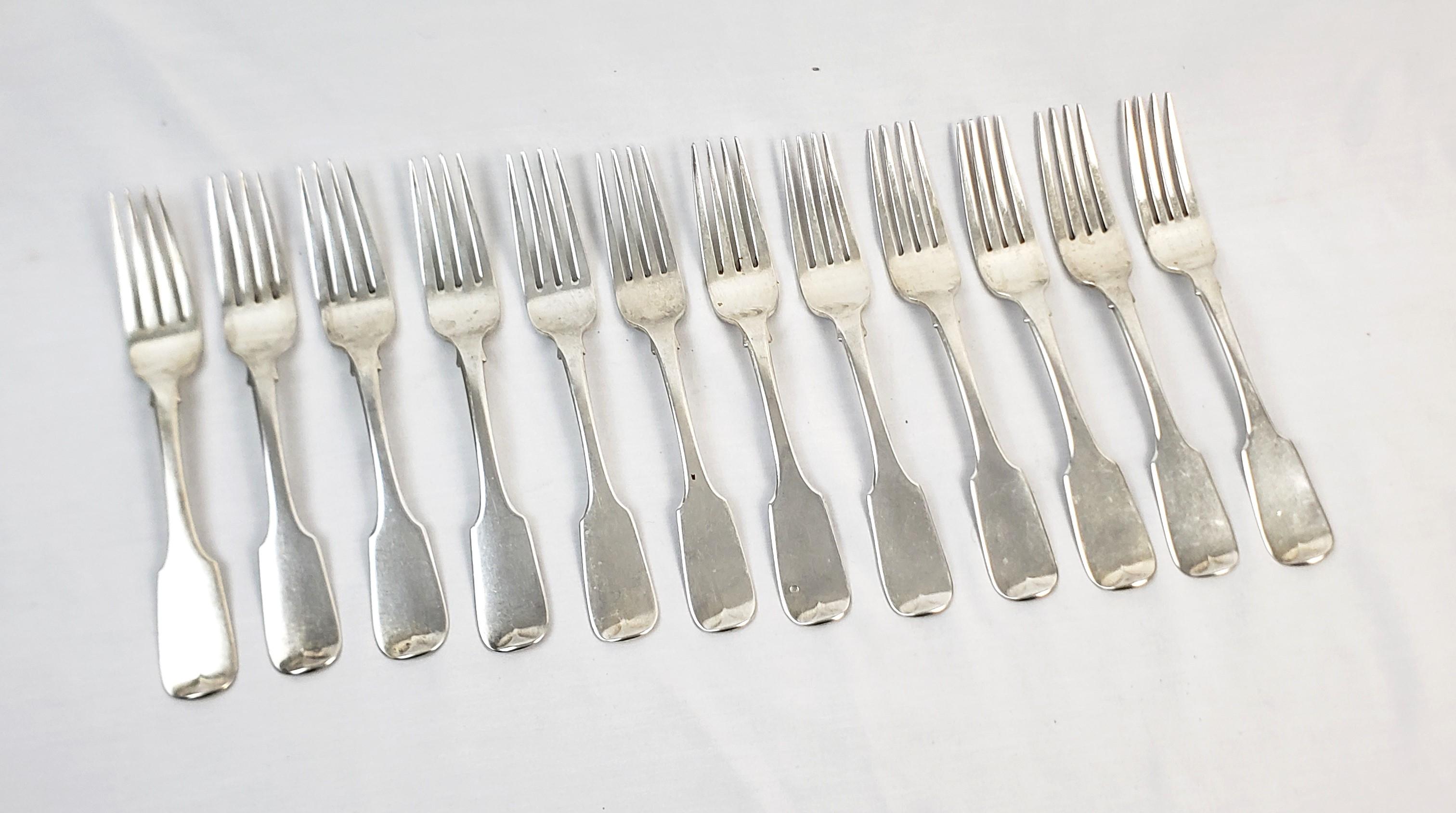This set of twelveantique dinner forks were made by Thomas Nortzen of Ireland and date to approximately 1830 and done in the period George IV style. These large and heavy forks are composed of sterling silver with a simple rippled accent on the base