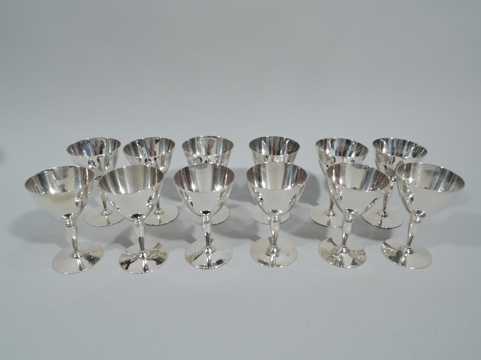 Set of 12 Art Deco sterling silver cocktail cups. Made by Tiffany & Co. in New York, circa 1915. Each: Cone on baluster mounted to circle. Spare and functional. Nice balance for swishing the booze around. Fully marked including pattern no. 18885