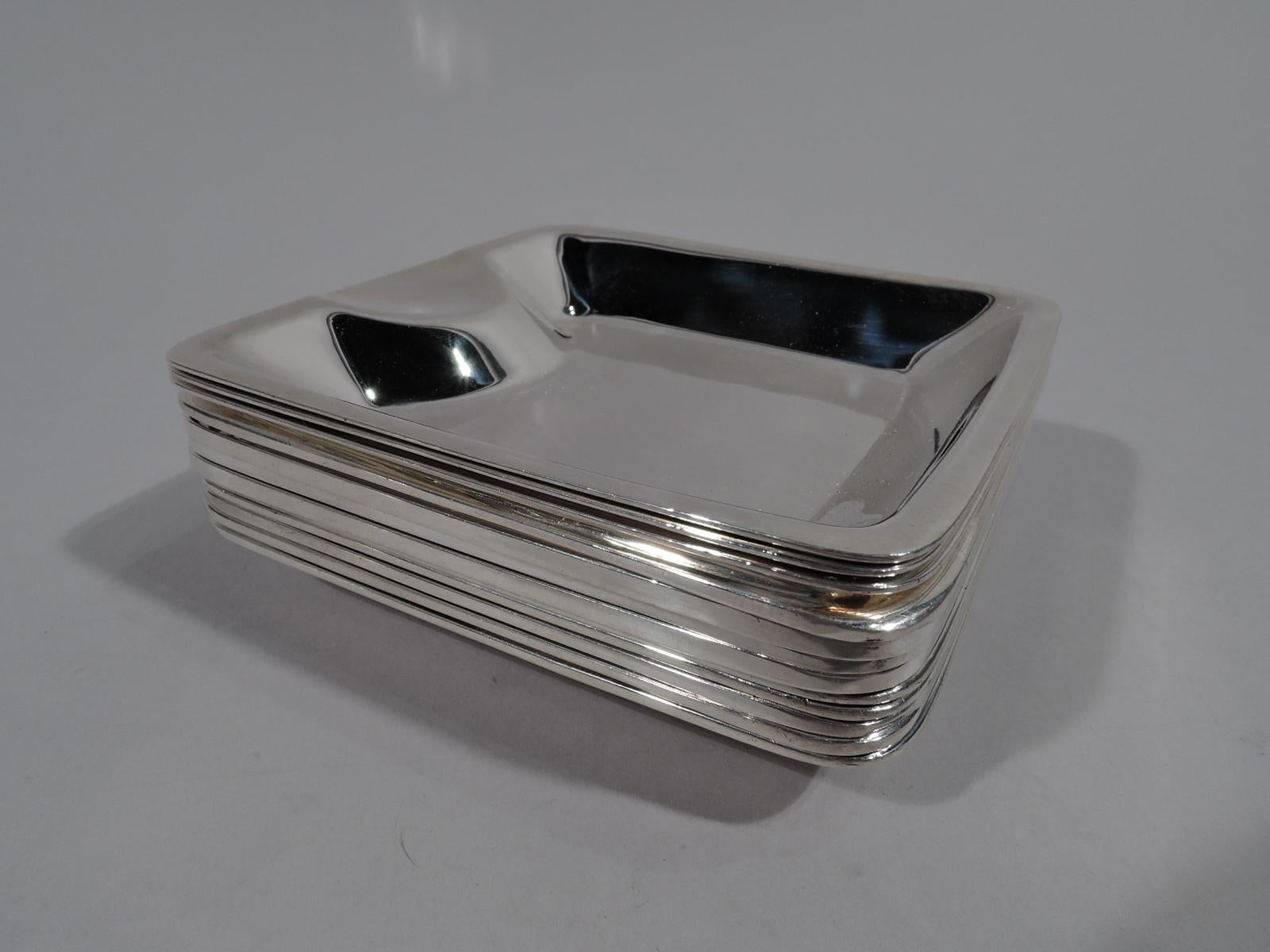 Set of 12 sterling silver ashtrays. Made by Tiffany & Co. in New York. Each: Rectangular with tapering sides and concave ovalish cradle. The individual size that makes smoking look stylish. Dangerous table accessories. Fully marked. Six have