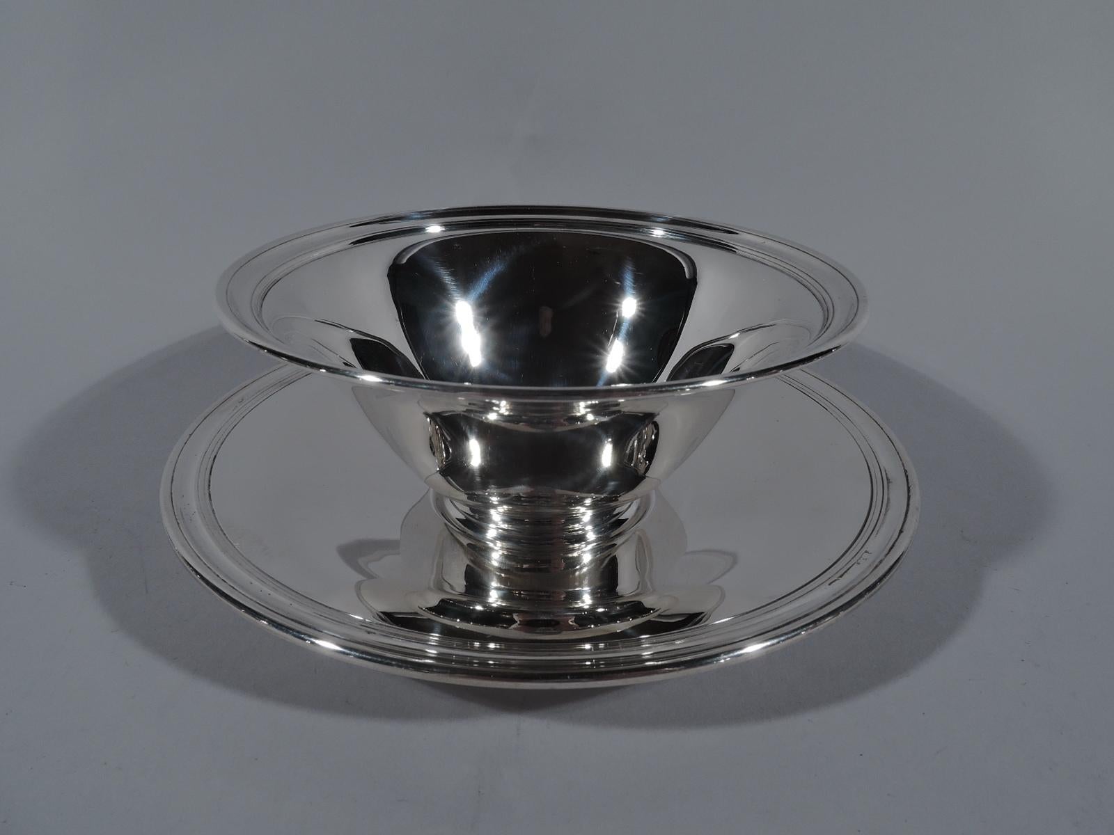 Twelve American modern sterling silver dessert bowls and plates. Made by Tiffany & Co. in New York, circa 1910. This set comprises 12 bowls and 12 plates. Each bowl: Conical with reeded interior rim and short stepped foot. Each plate: Well with wide