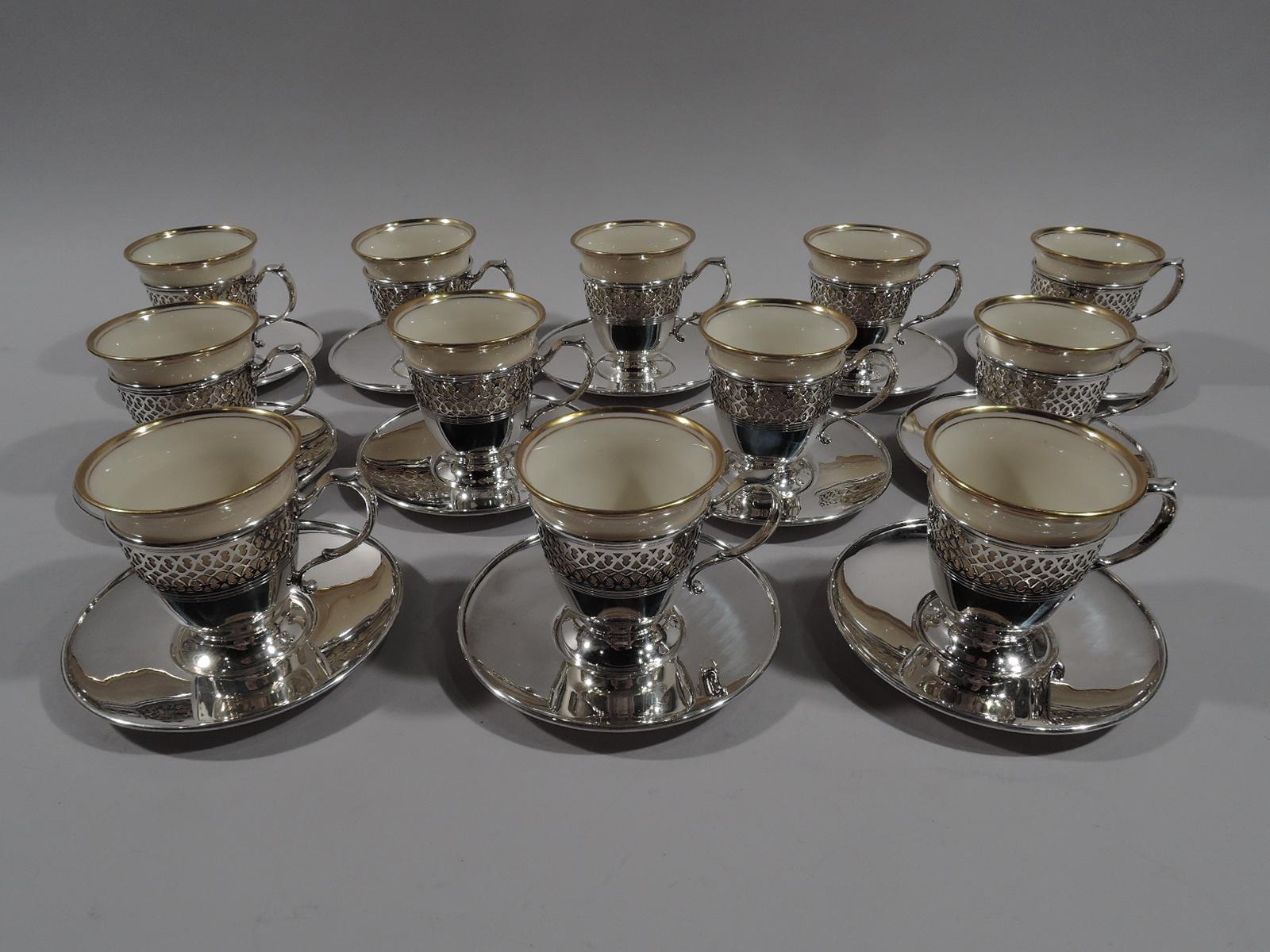 Set of 12 Edwardian sterling silver demi-tasse holders and saucers. Made by Tiffany & Co. in New York, circa 1914. This set comprises 12 holders and 12 saucers. Each holder: Conical with spread foot and capped s-scroll handle. Scrolling pierced band