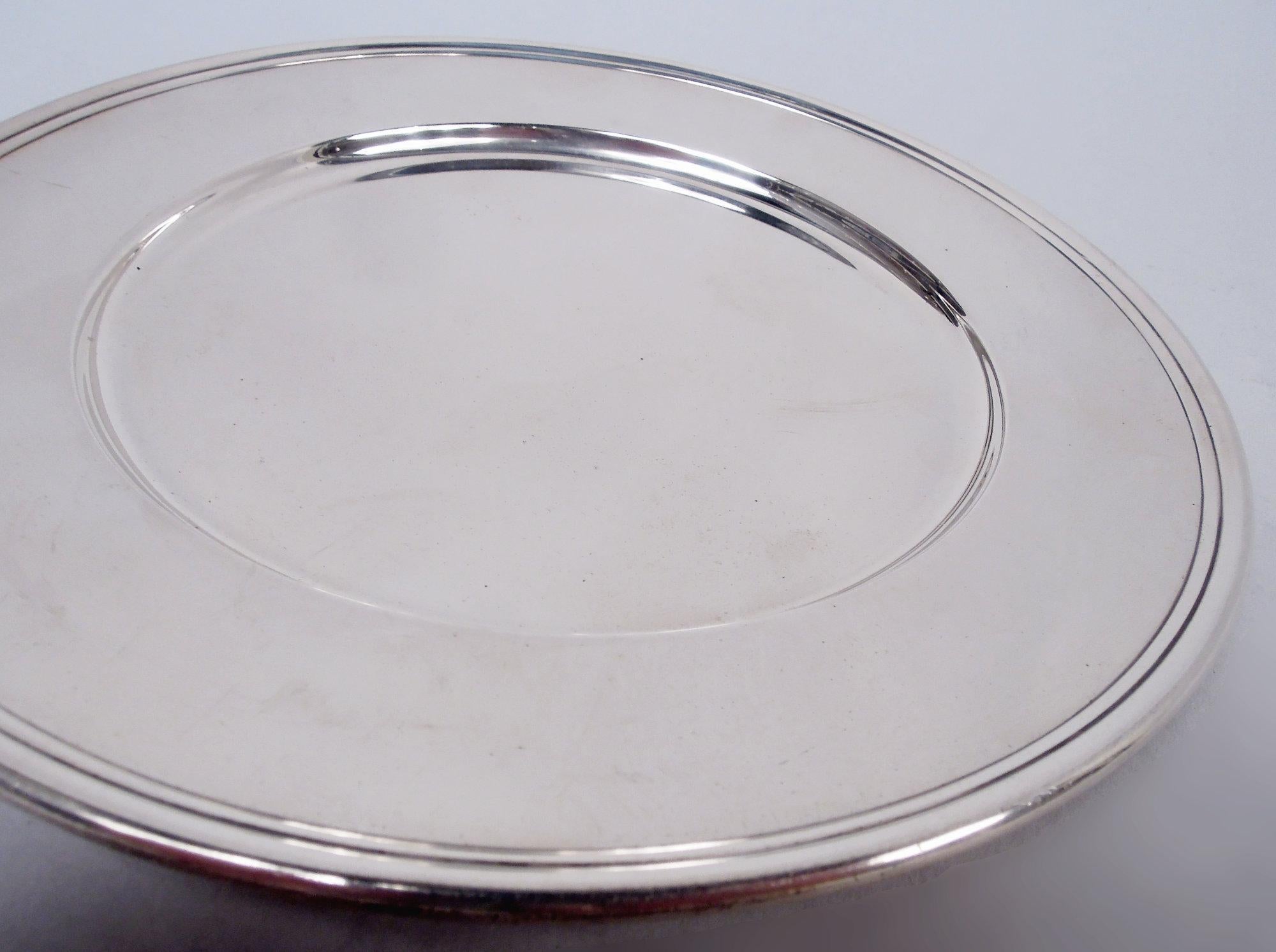 Set of 12 Modern sterling silver bread and butter plates. Made by Tiffany & Co. in New York, ca 1922. Each: Round well, tapering shoulder and molded rim. Fully marked including maker’s stamp, pattern no. 20065 (first produced in 1922), order no.
