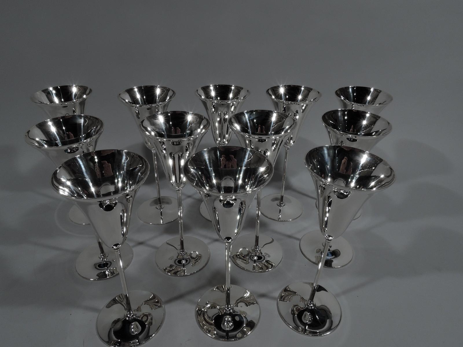 Set of 12 tall and Modern sterling silver flutes. Made by Tiffany & Co. in New York, ca 1924. Each: Conical “tulip” bowl on thin cylindrical shaft mounted to flat circular foot. For chic sipping. Fully marked including pattern no. 20468 (first