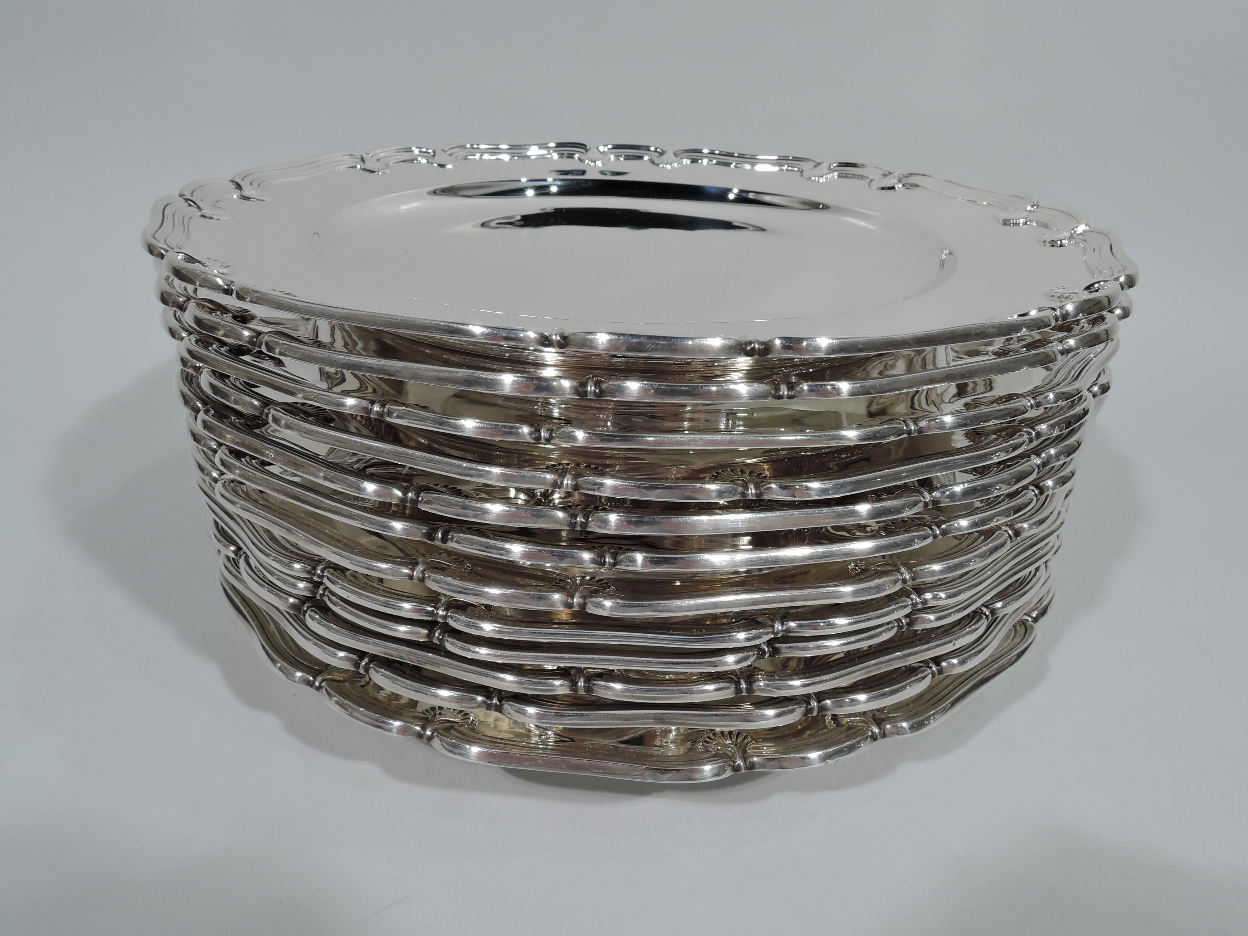 Set of 12 sterling silver appetizer plates. Made by Tiffany & Co. in New York, circa 1910. Each: Circular well, short foot, tapering shoulder, and scrolled and molded rim with applied scallop shells. Perfect for the buffet. Hallmark includes pattern