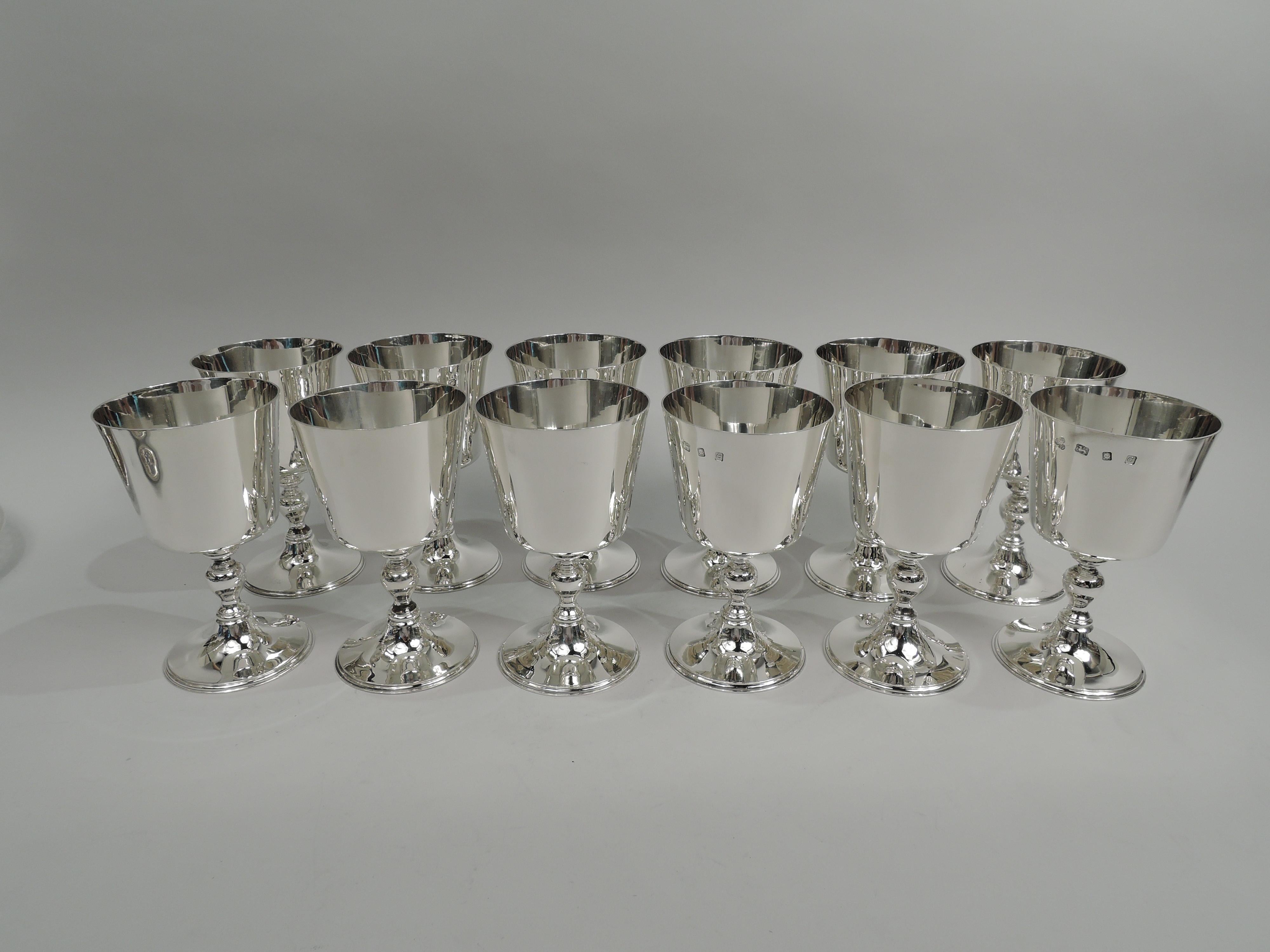 Set of 12 traditional sterling silver goblets. Made by Wakely & Wheeler in London in 1960. Each: Flat-bottomed bowl with straight and tapering sides, baluster support, and raised round foot. Festive with nice proportions and balance. Fully marked.