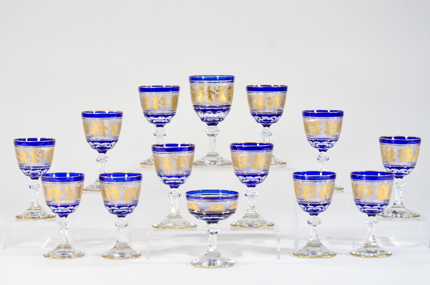 This is a magnificent set of 12 rare sized wine goblets made by Val St. Lambert. Each one is hand blown with cobalt crystal overlay, cut to clear with cameo cut frieze of Roman figures embellished with gold leaf. This pattern is one of Val St.