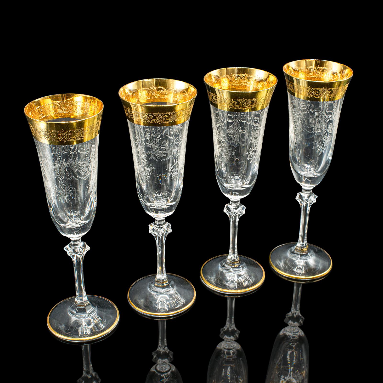Voici un magnifique ensemble de 12 flûtes à champagne millésimées. Suite de verres à vin de style CIRCA, recouverts de feuilles d'or, datant de la fin du XXe siècle, vers 1980. Merveilleusement décoratif avec ses accents dorés et son motif gravé, il