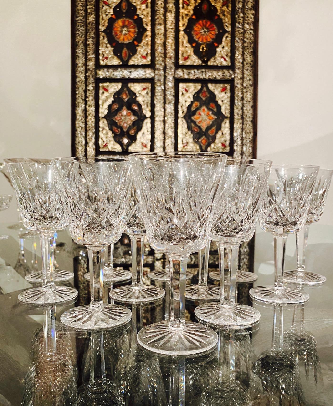 Set of twelve luxury crystal wine glasses from Waterford Crystal. The Lismore Collection is perhaps Waterford's most distinguished design featuring a hand blown crystal with the pattern's signature diamond and wedge cuts. First introduced in the