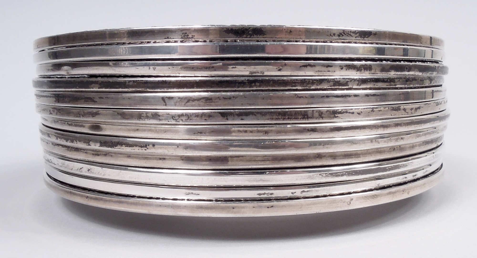 Set of 12 Navarre sterling silver bread and butter plates. Made by Watson Company in Attleboro, Mass., ca 1920. Each: Round with deep well. Shoulder tapering with chased shell and flower clusters between curvilinear frames interspersed with leafing